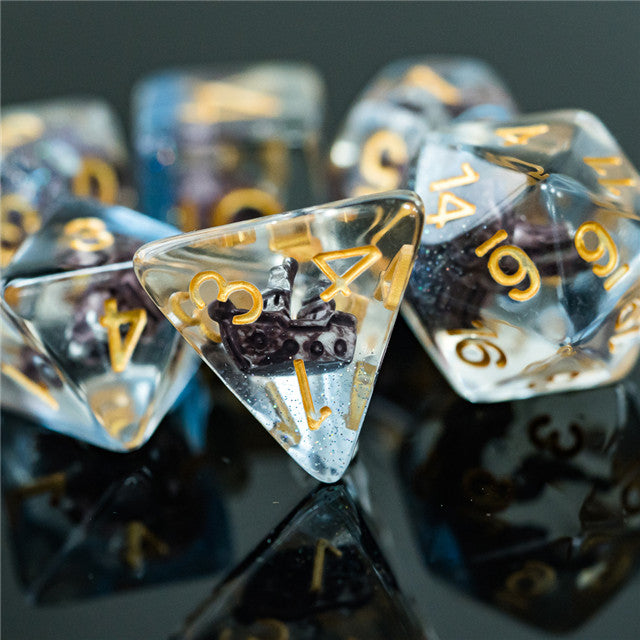 Boat Dice - Clear polyhedral dice set with gold numbers and embedded miniature black boat figures inside each die.