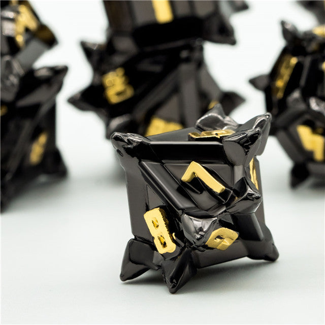 Caltrop Black Metal Dice Set - Black metal caltrop-shaped dice with angular spikes and gold numbering on each face.