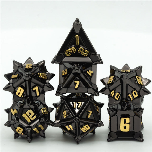 Caltrop Black Metal Dice Set - Black metal dice set with gold numbers featuring sharp-edged, geometric shapes including d4, d6, d8, d10, d12, and d20.