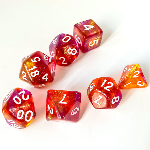 Sunset Glitter Acrylic Dice Set - Set of seven glittery acrylic dice in sunset colors with white numbering, including d20, d12, d10, d8, d6, d4, and.