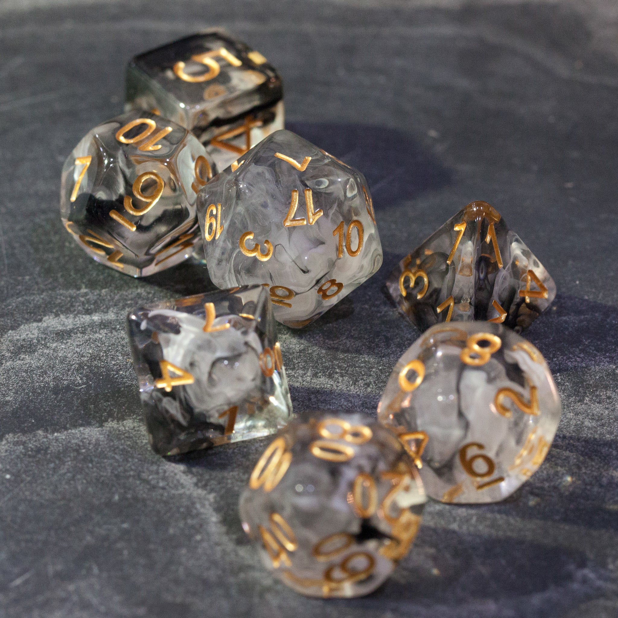 Black & White Smoke Dice Set - Set of translucent black and white smoke dice with gold numbering on a dark surface.