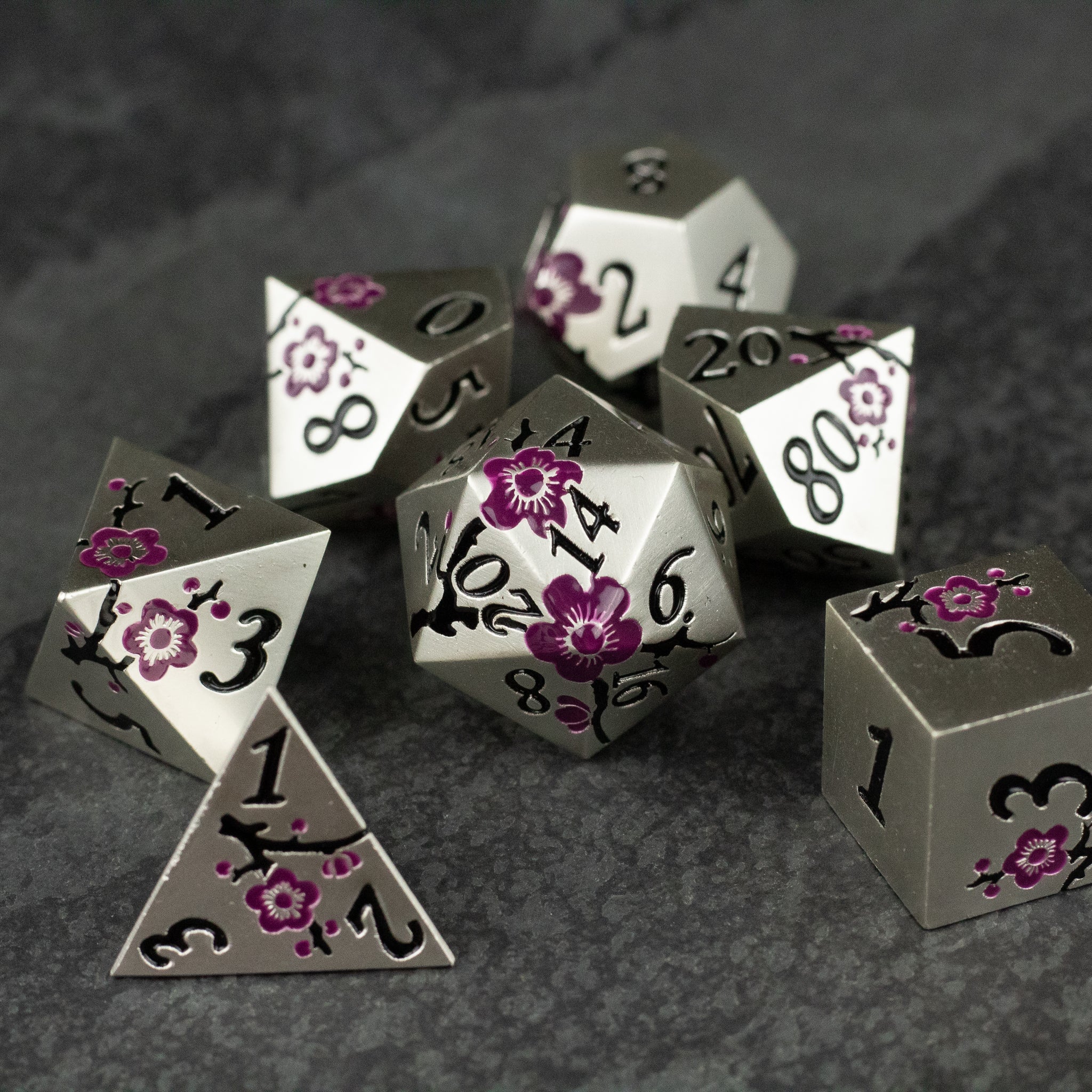 Silver & Maroon Metal Flower Dice - Set of silver metal dice with maroon floral designs and black numbering on a dark textured surface.
