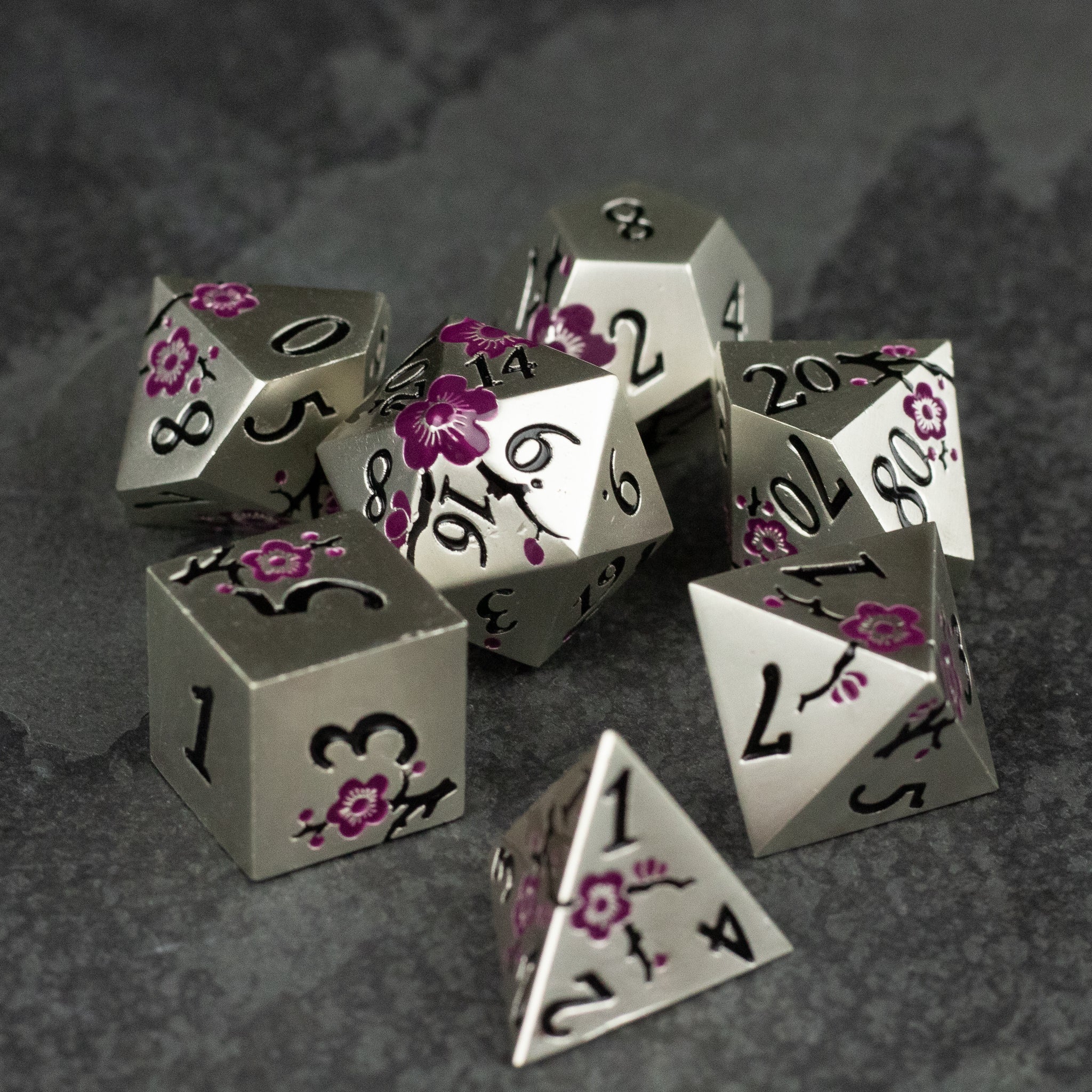 Silver & Maroon Metal Flower Dice - Set of silver metal polyhedral dice with maroon floral engravings and black numbers on a dark textured background.