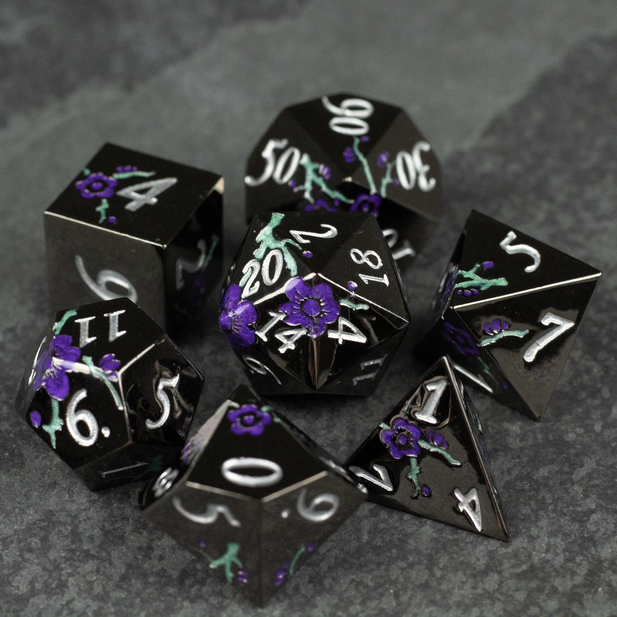 Black and Purple Metal Flower Dice - Black and purple metal polyhedral dice set with floral designs and white numbering.