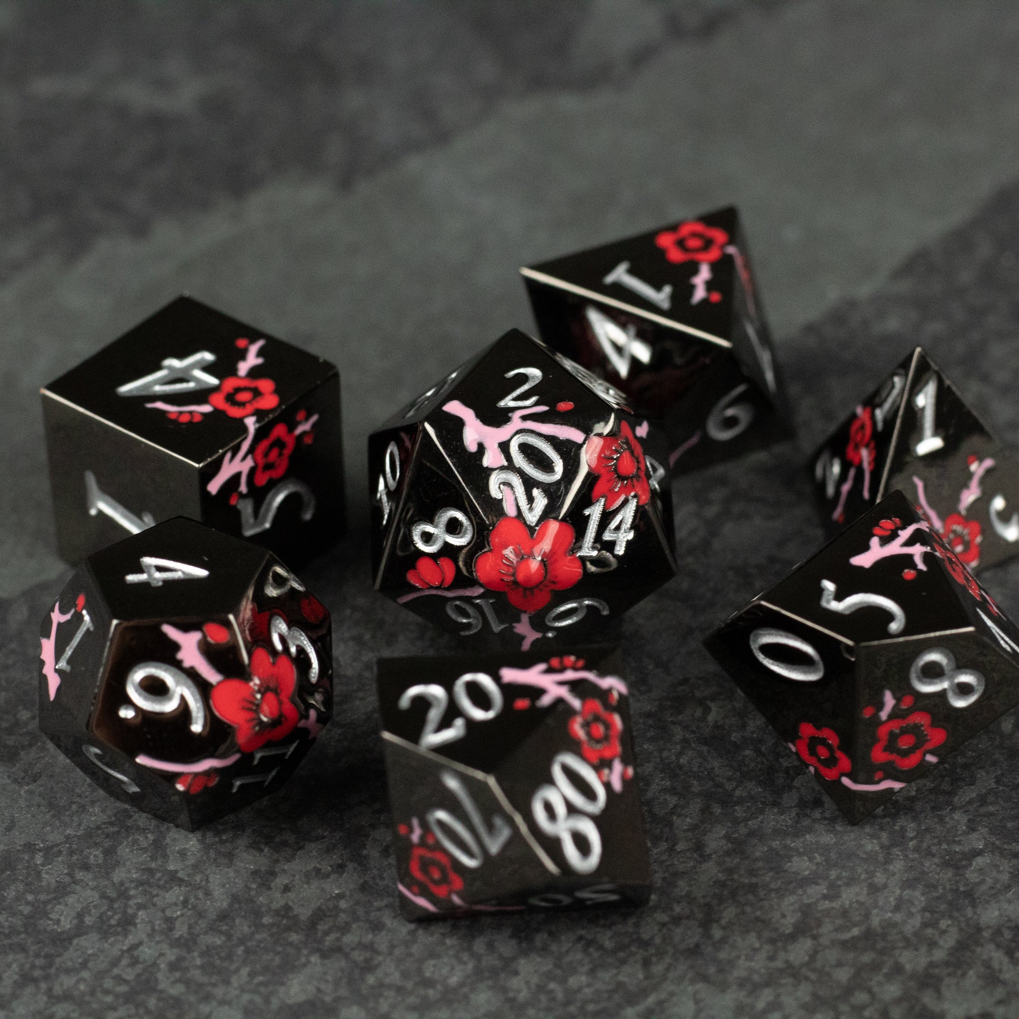 Black & Red Metal Flower Dice - Black metal gaming dice set with red and pink flower engravings and white numbers.