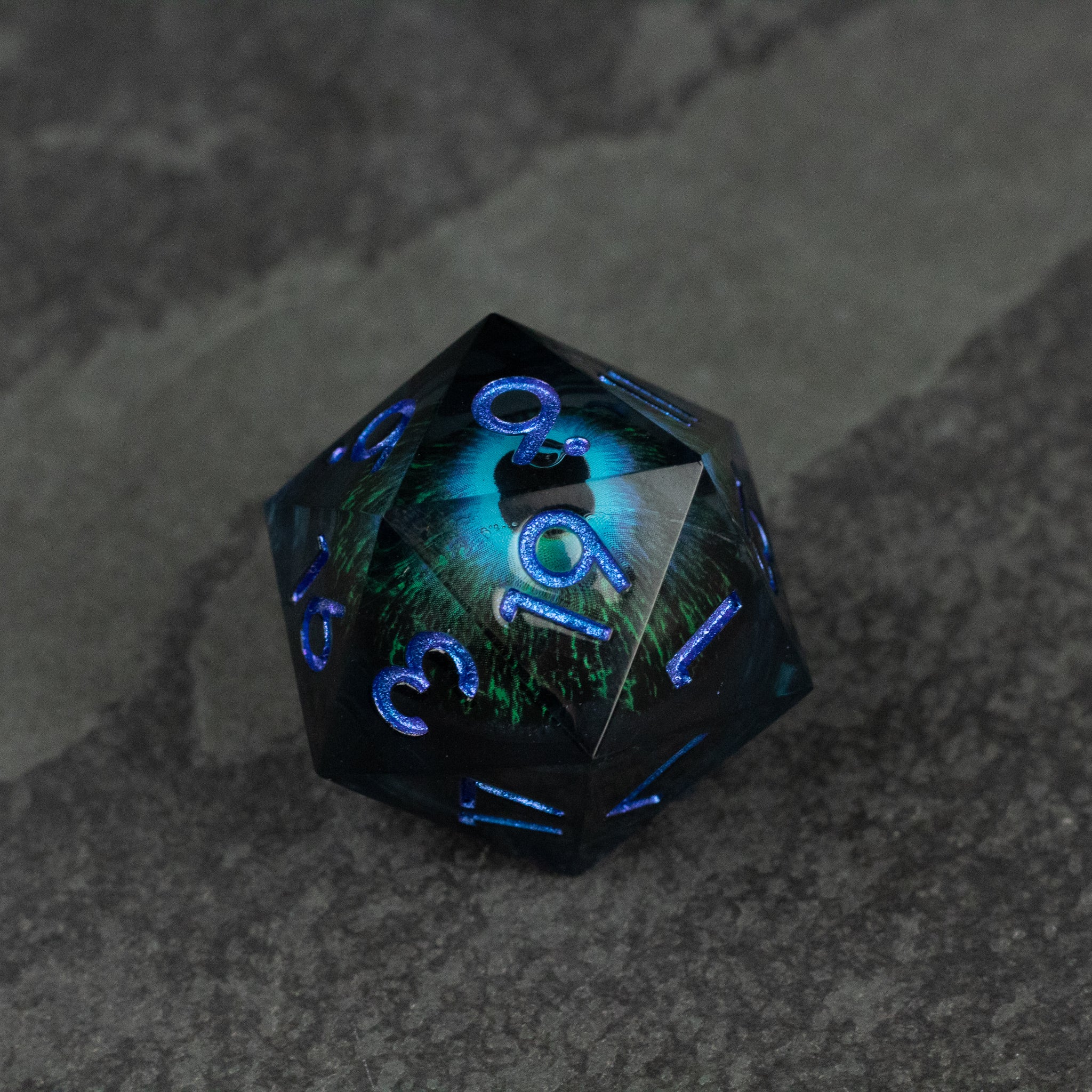 33mm Liquid Floating Eye - Blue - 33mm blue liquid core d20 die with floating numbers and glossy finish on dark surface.