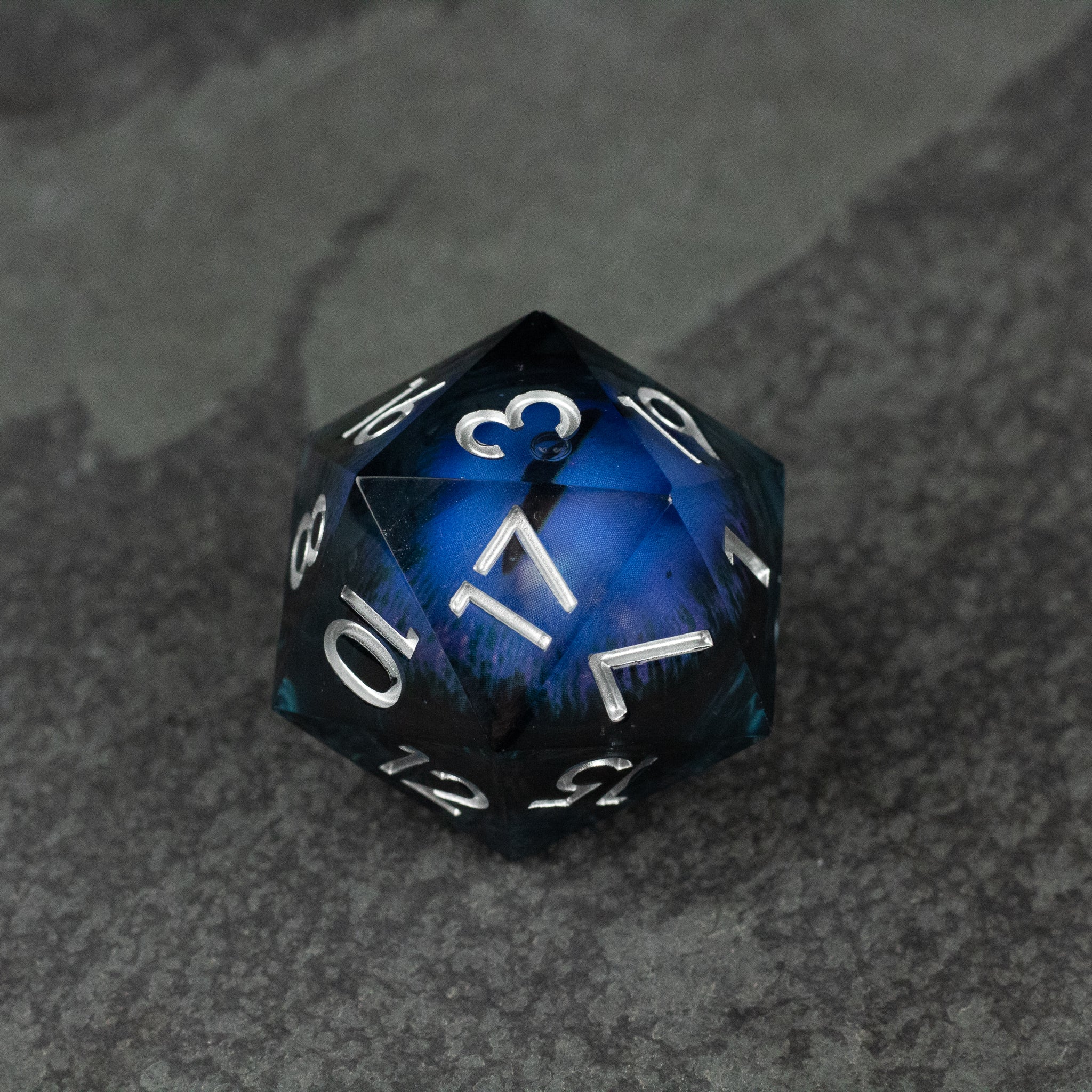 33mm Liquid Floating Eye - Purple - 33mm blue and purple liquid-filled 20-sided die with white numbers on dark textured surface.