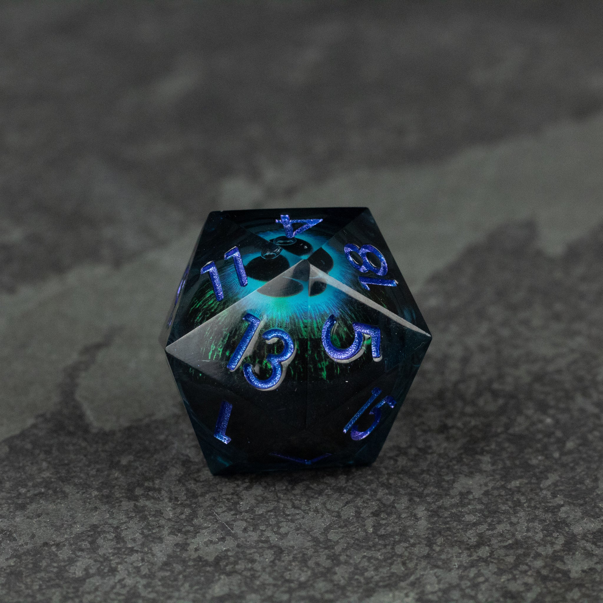 33mm Liquid Floating Eye - Blue - 33mm black 20-sided dice with glowing blue liquid floating core and blue numbers.