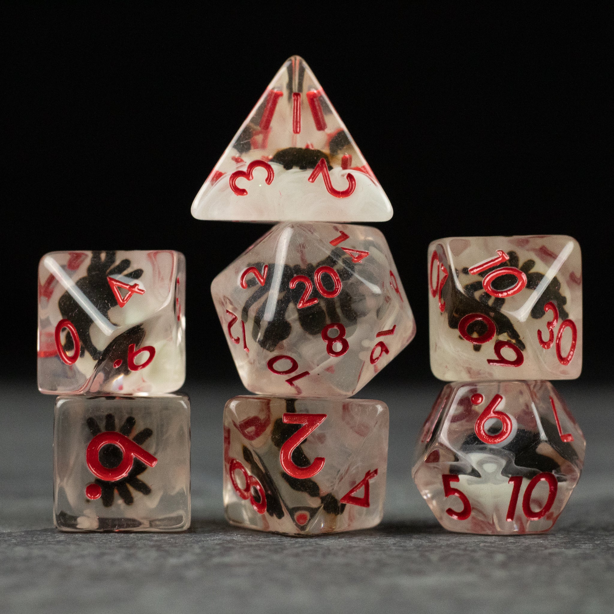 Black Spider Dice Set - White - Transparent dice set with black spider inclusions and red numbers, includes multiple polyhedral shapes.