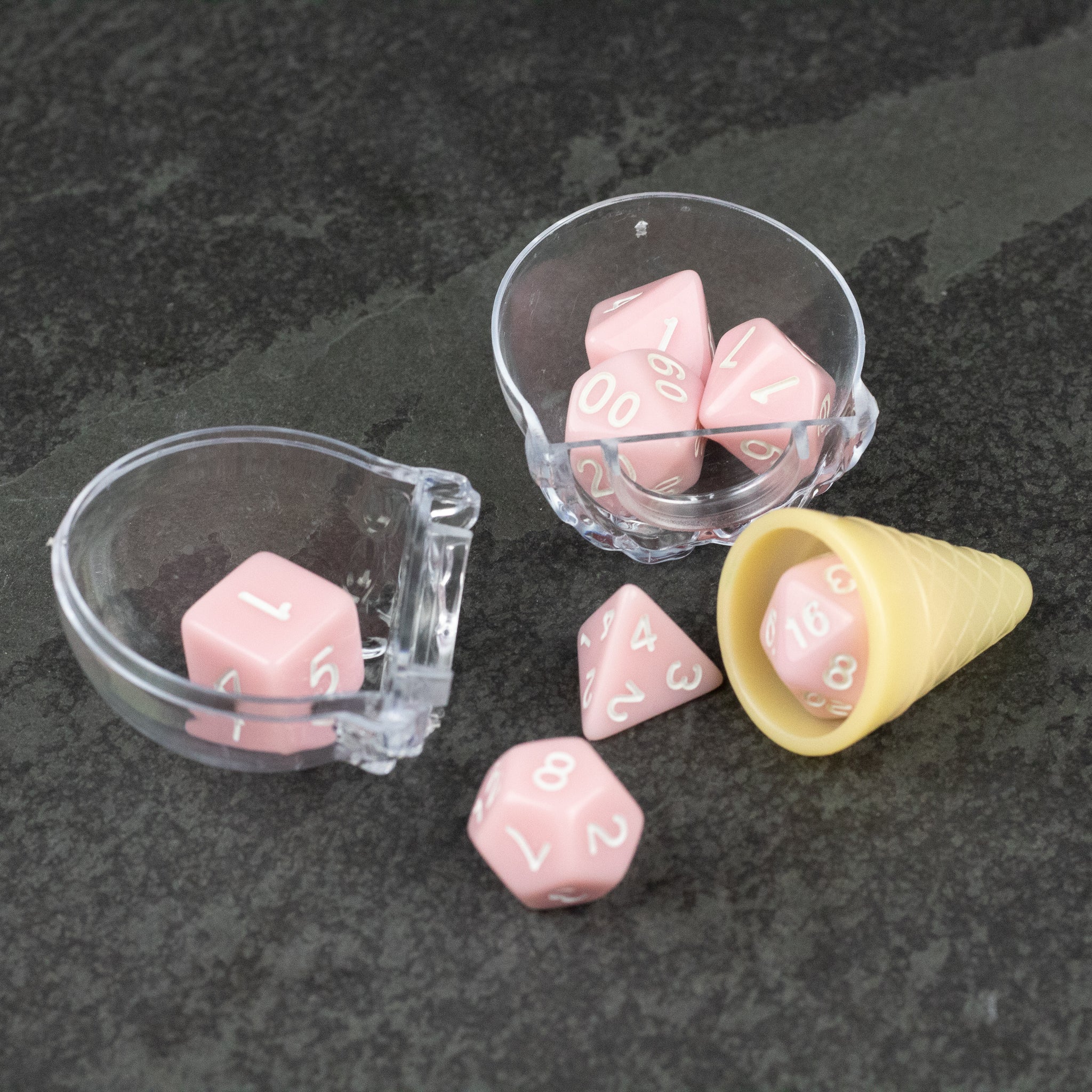Dice Cream Cones - Set of pastel pink polyhedral dice with white numbers, displayed with a clear plastic scoop and a small yellow cone-shaped.