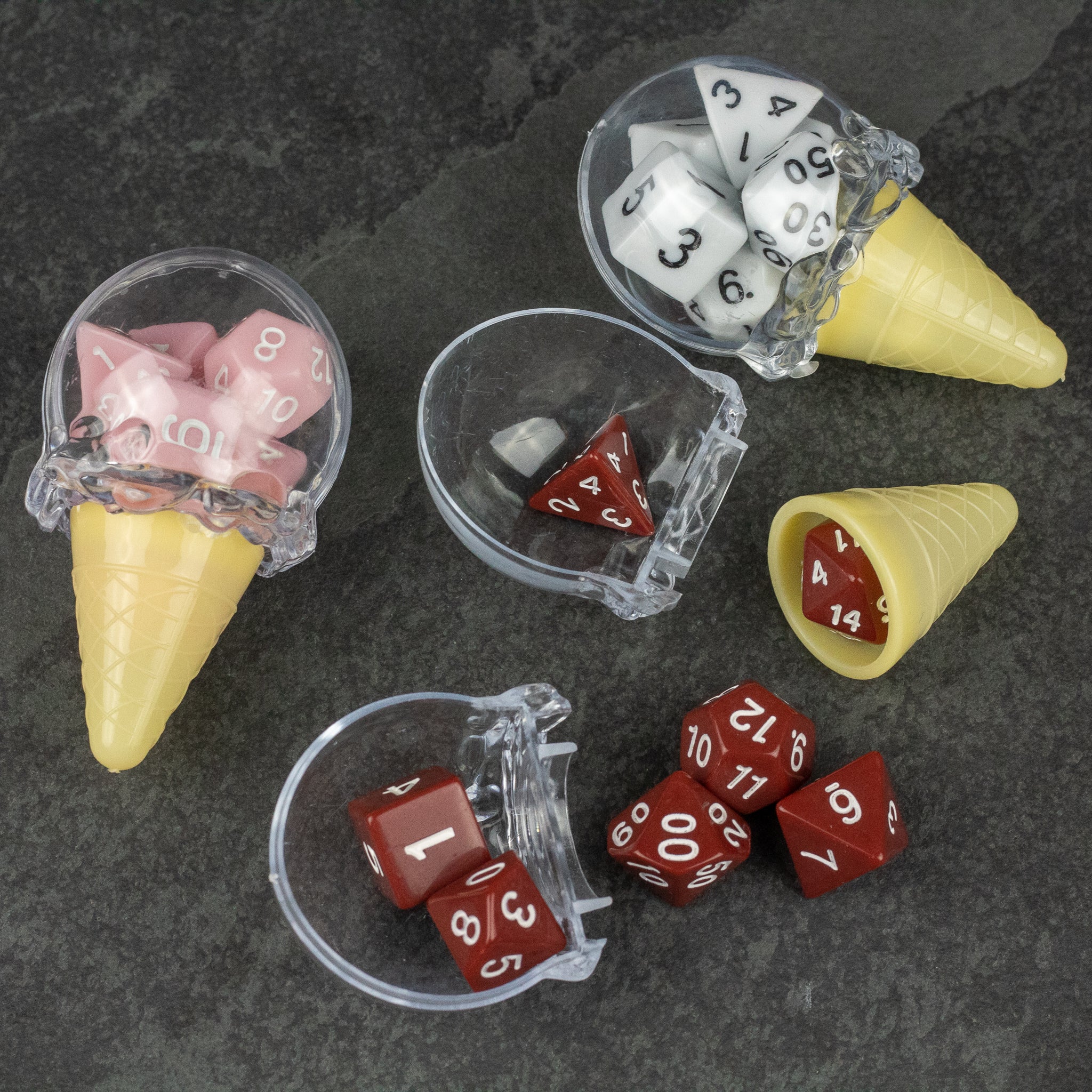 Dice Cream Cones - Set of translucent plastic ice cream cones holding various polyhedral dice in white, red, and pink colors on a dark textured