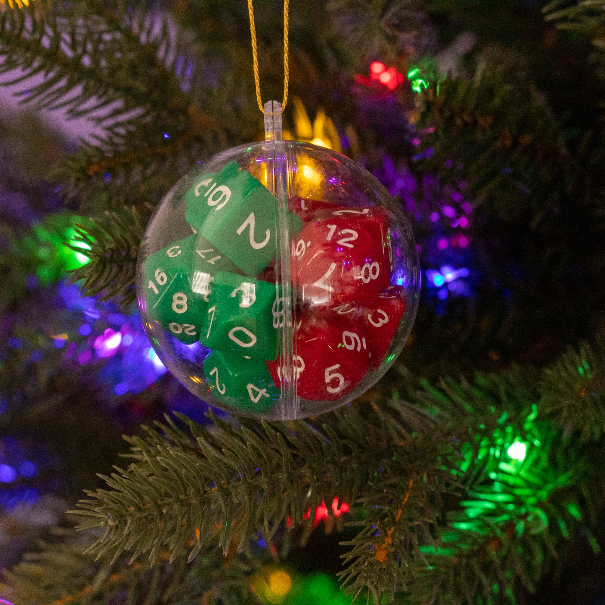 Christmas Dice Ball Ornaments - Clear round ornament filled with red and green multi-sided dice hanging on pine tree with colorful lights.