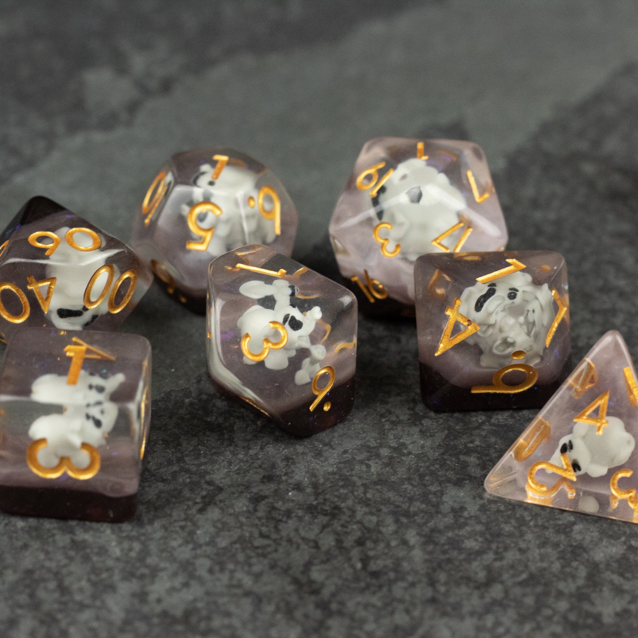 Elephant Dice Set - Translucent purple polyhedral dice with gold numbers, each containing a small white elephant figure inside.