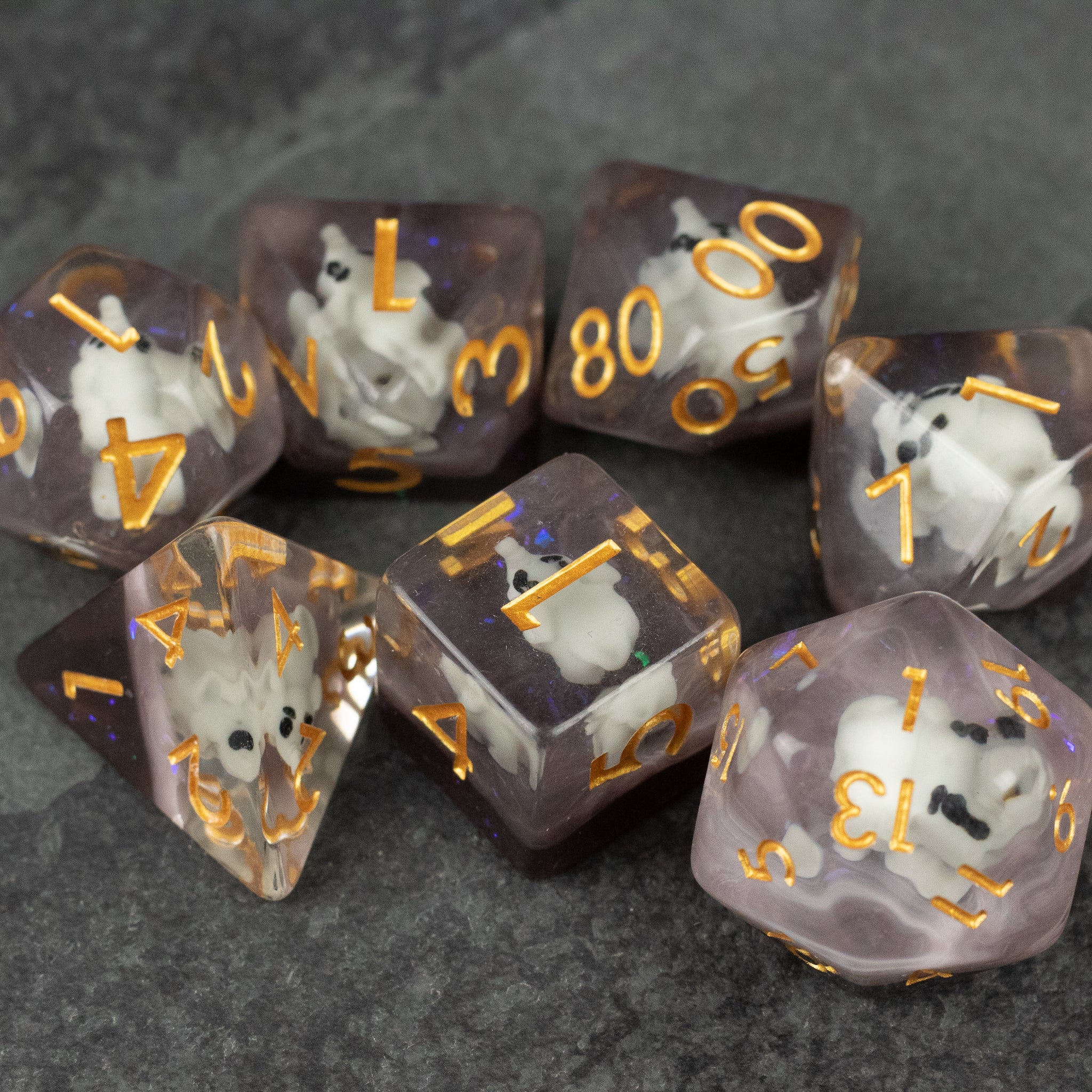 Elephant Dice Set - Translucent purple and white multi-sided dice set with gold numbers featuring small elephant figures inside each die.