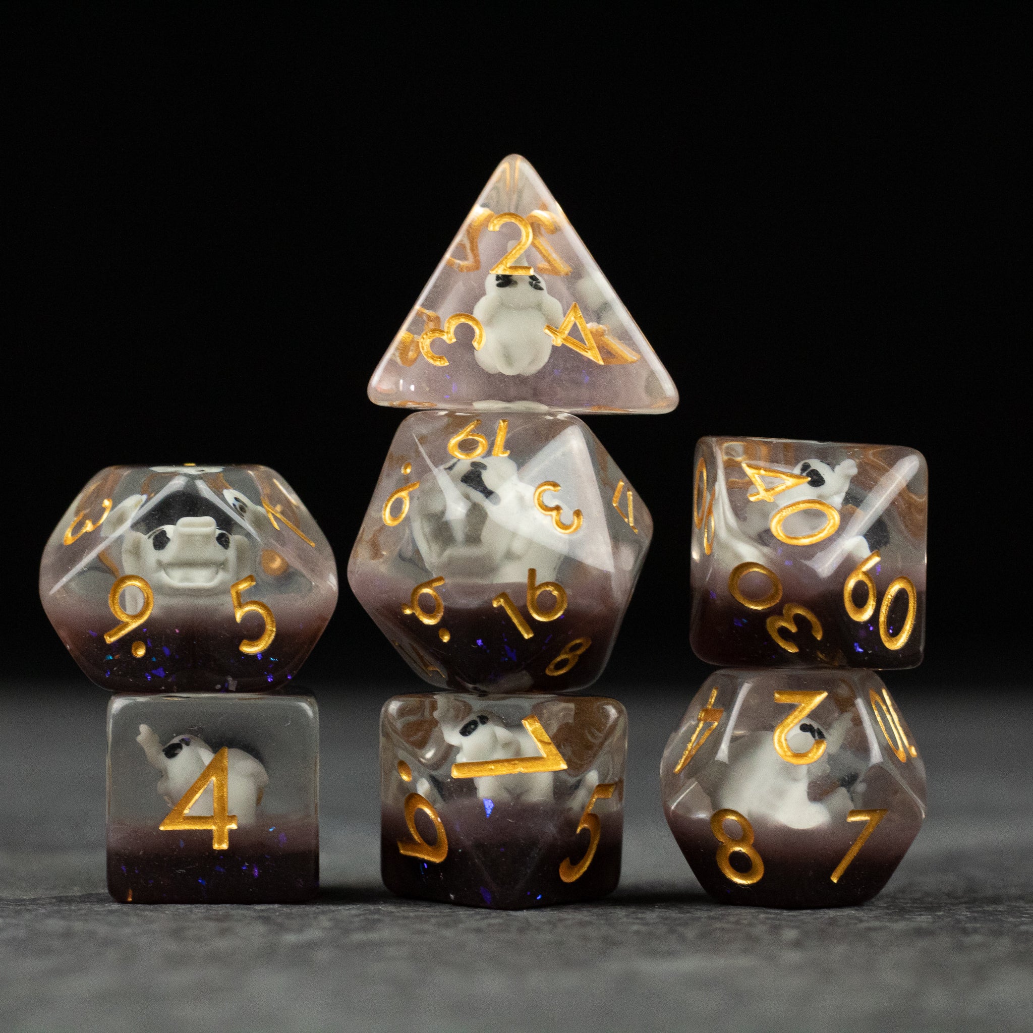 Elephant Dice Set - Seven translucent purple polyhedral dice with gold numbers, each featuring a small white elephant icon inside.