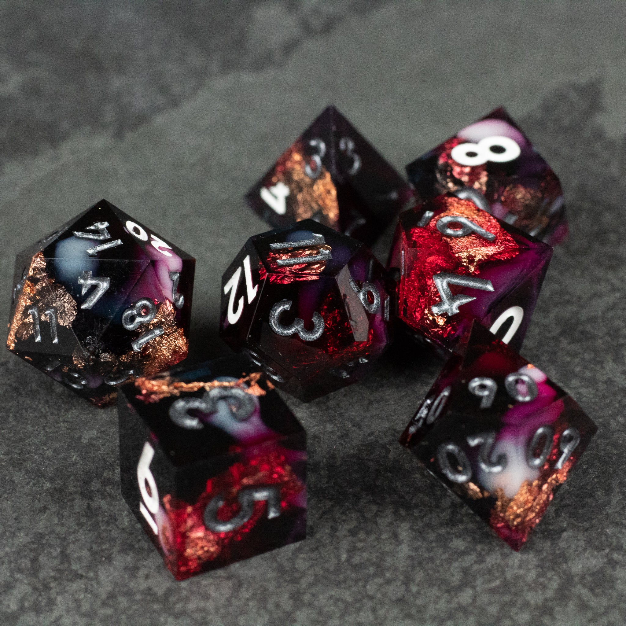 Sanguine Sacrament Dice Set - Seven sharp-edged dice in black and deep red marbled resin with white numbering and copper-colored metallic accents.