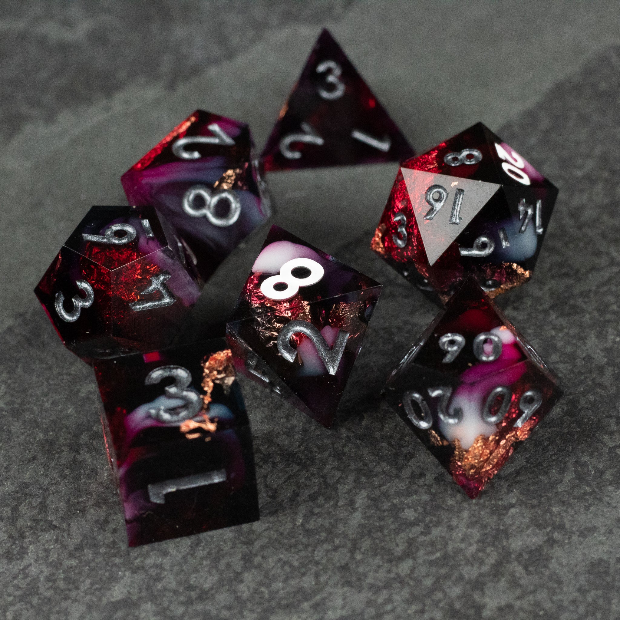 Sanguine Sacrament Dice Set - Deep red and black sharp-edged polyhedral dice set with white numbering and metallic copper inclusions.