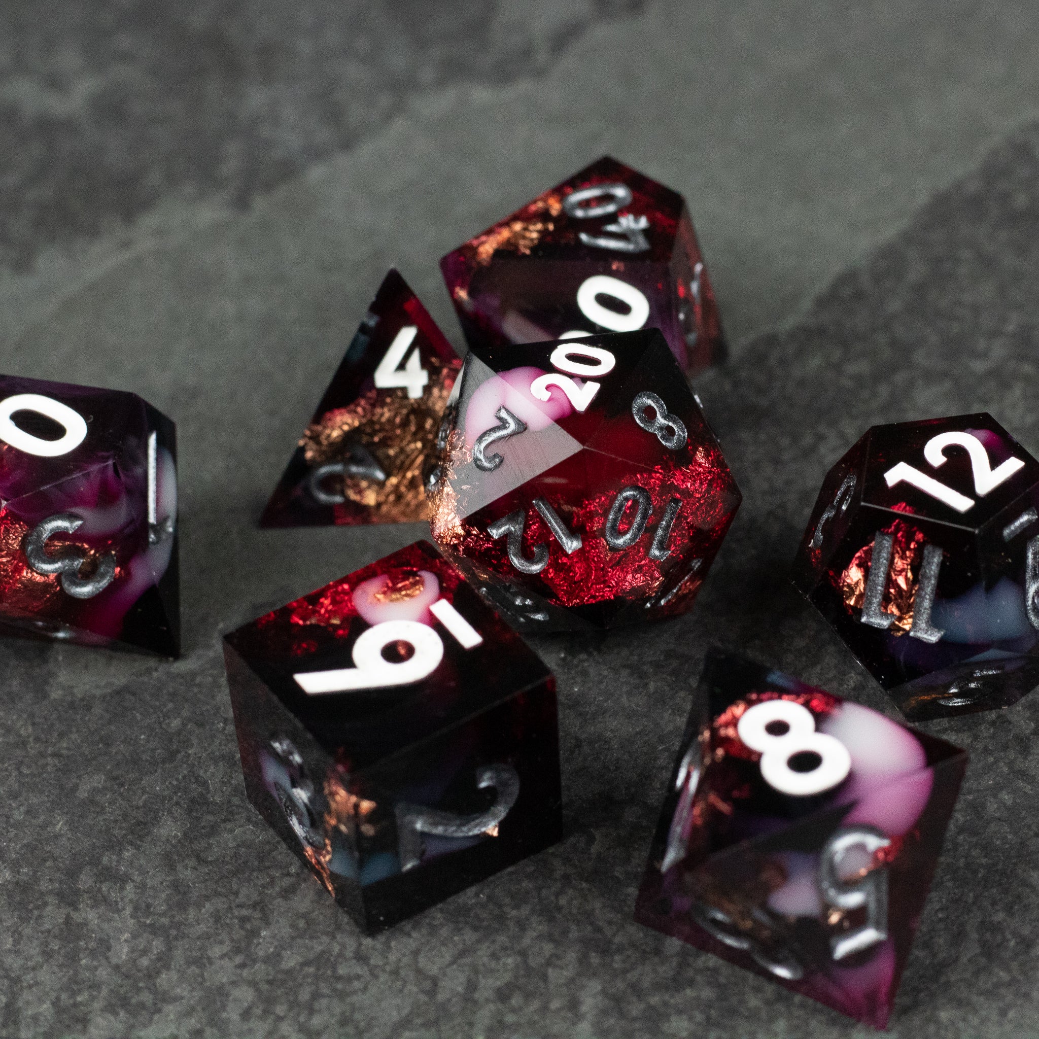 Sanguine Sacrament Dice Set - Translucent black gaming dice with sharp edges, featuring red and orange fiery inclusions and white numbering.