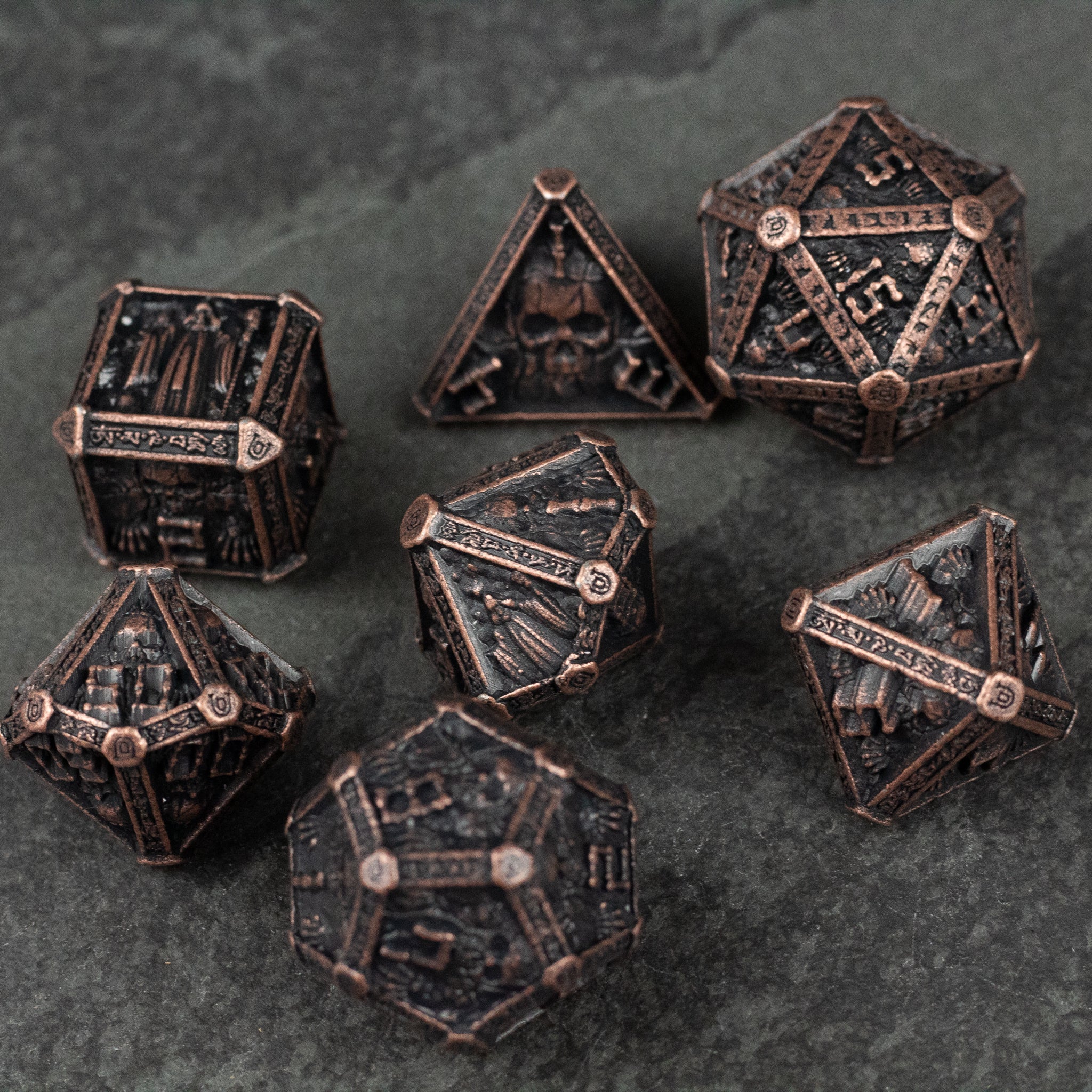 Bronze Necromancer Metal Dice Set - Bronze metal dice set with intricate skull and necromancer-themed engravings on dark background.