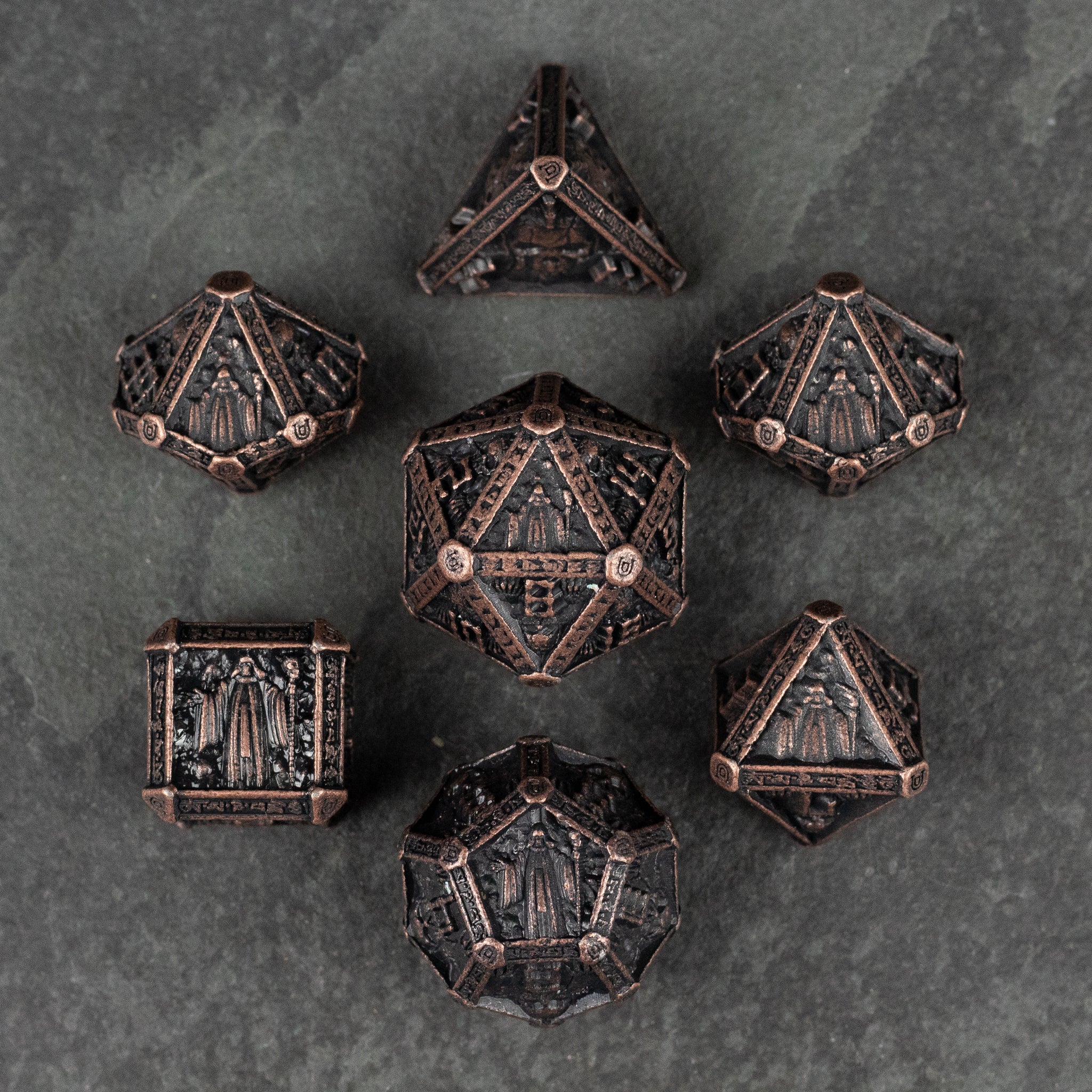 Bronze Necromancer Metal Dice Set - Set of seven bronze-finished metal dice with intricate necromancer-inspired engravings on each face.