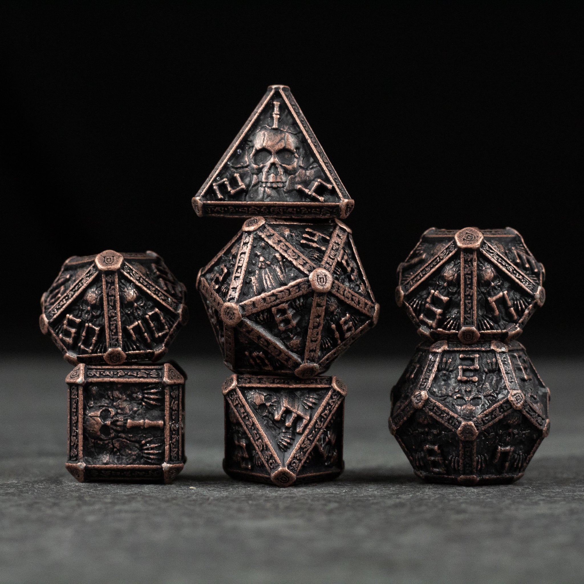 Bronze Necromancer Metal Dice Set - Bronze metal necromancer-themed dice set with skull and bone engravings, various polyhedral shapes.