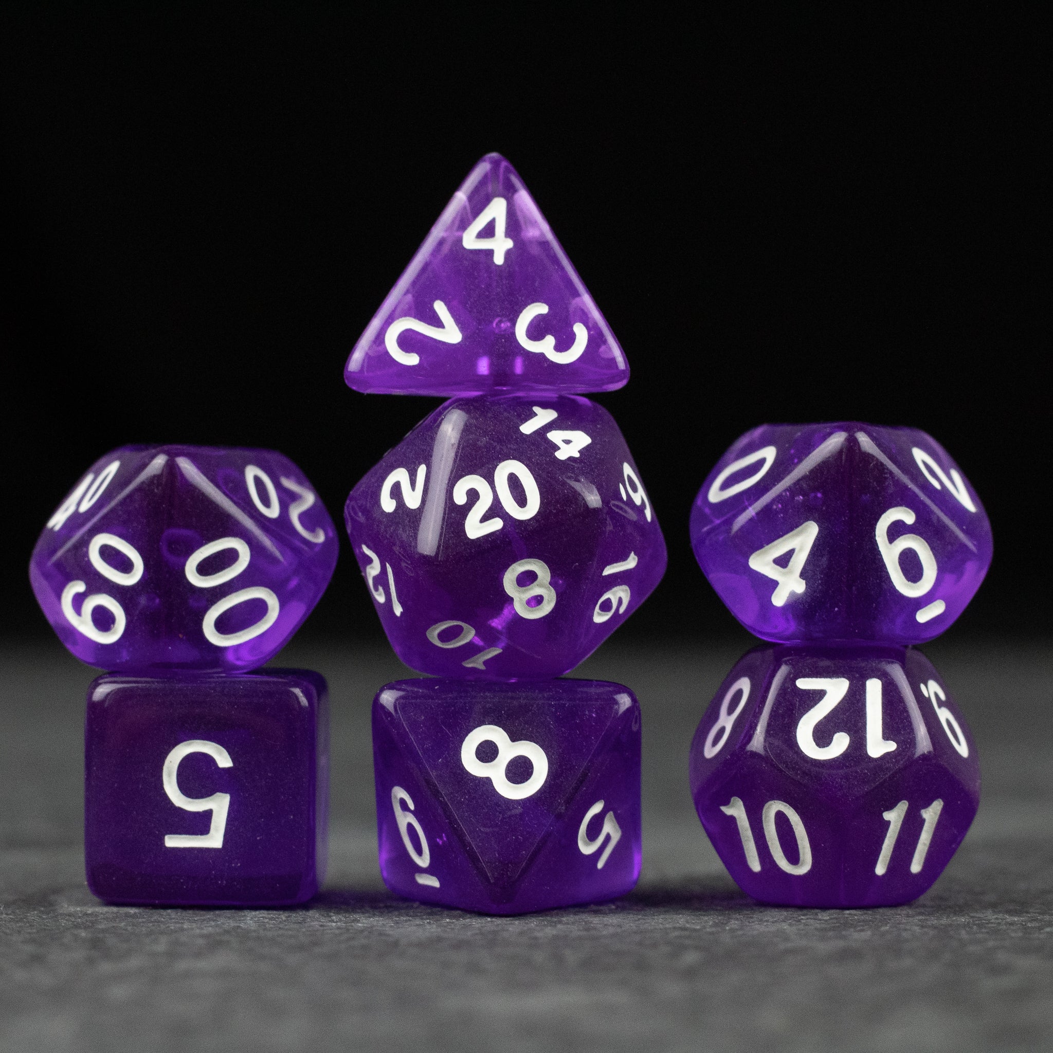 Purple Transparent Dice Set - Set of seven purple transparent polyhedral dice with white numbers for tabletop gaming.