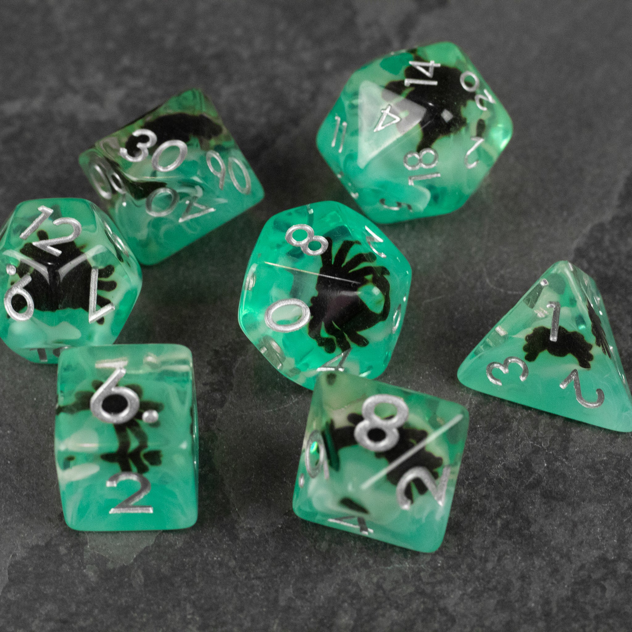 Black Spider Dice Set - Green - Translucent green polyhedral dice set with black spider designs and white numbering.