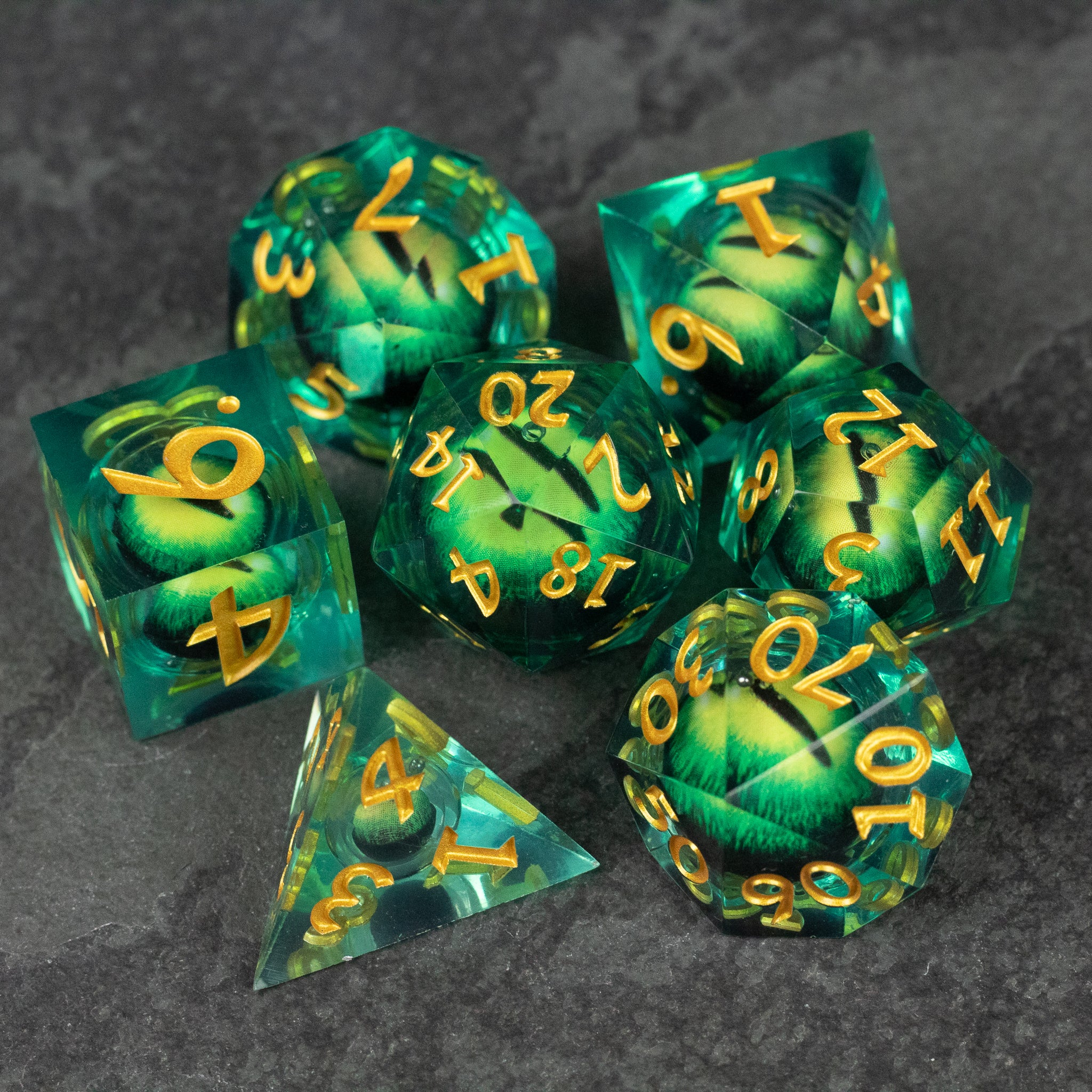 Green Beholder's Eye Dice Set - Green transparent polyhedral dice set with yellow numbers and swirling liquid core design.