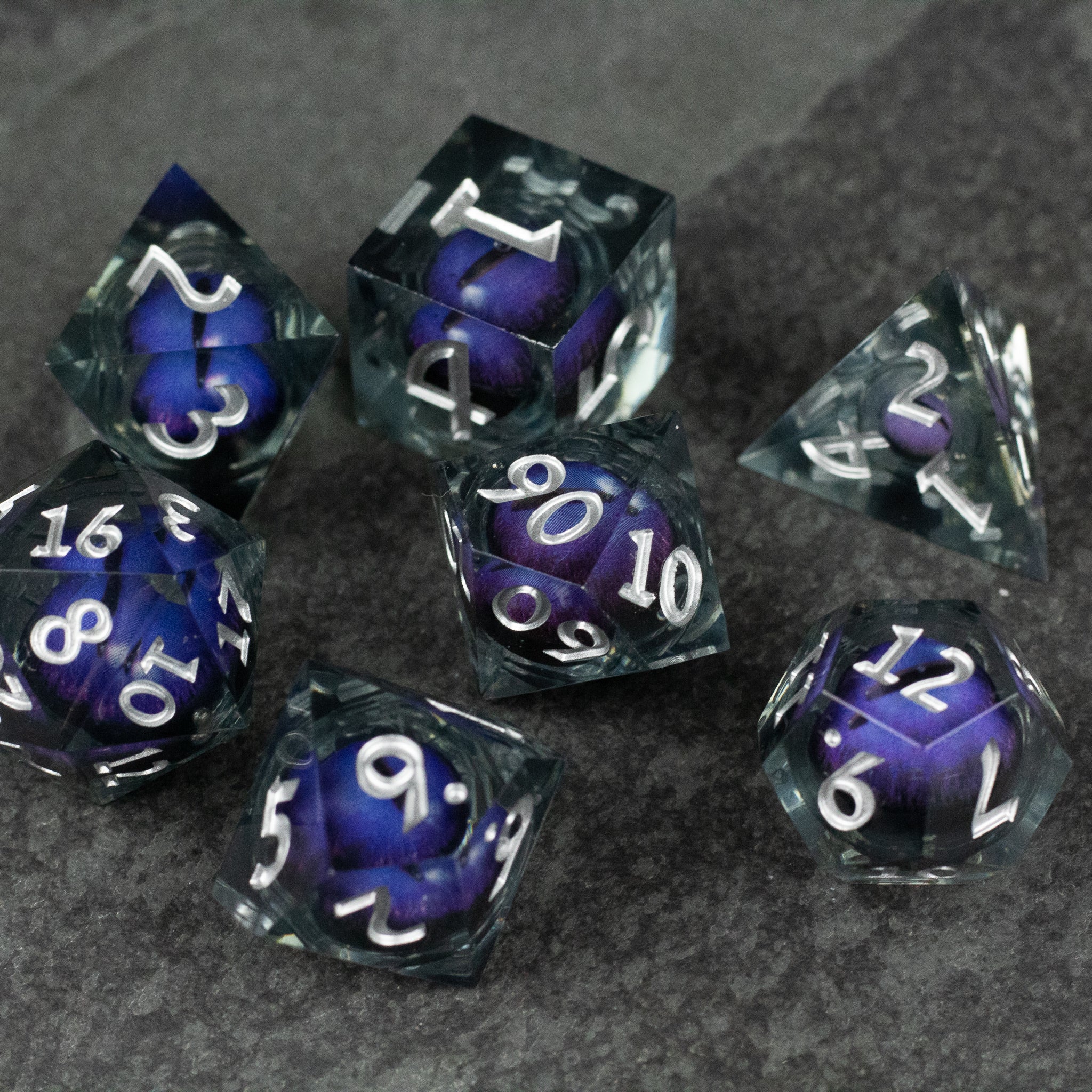 Purple Beholder's Eye Dice Set - Set of seven polyhedral dice with clear edges and a deep purple liquid core, white numbers visible on each face.