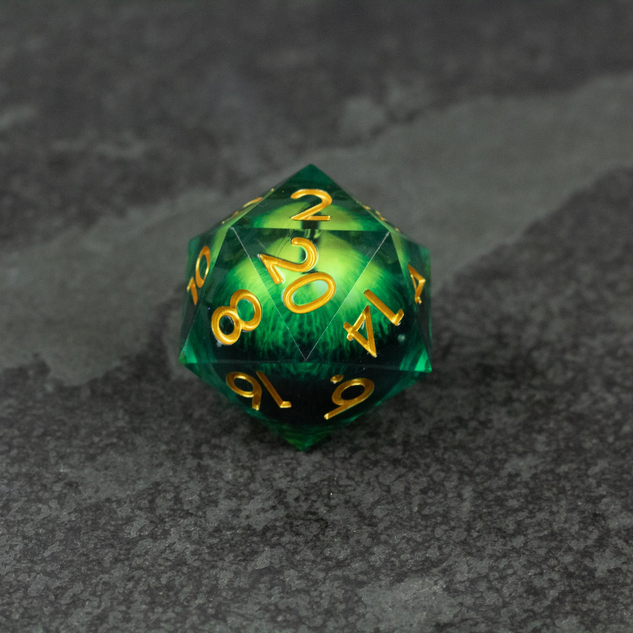 33mm Liquid Floating Eye - Green - 33mm green liquid core 20-sided die with gold numbering on dark textured surface.