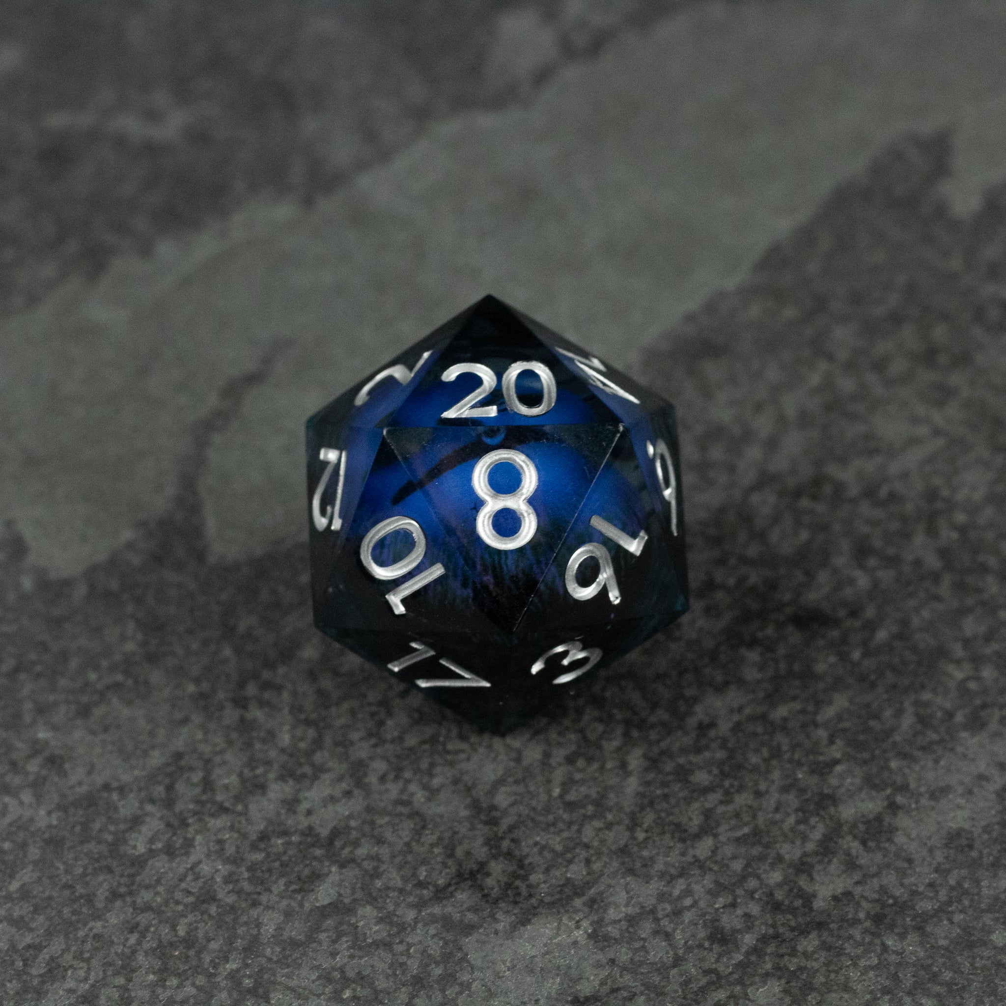 33mm Liquid Floating Eye - Purple - 33mm black 20-sided die with a floating blue liquid core and white numbers.