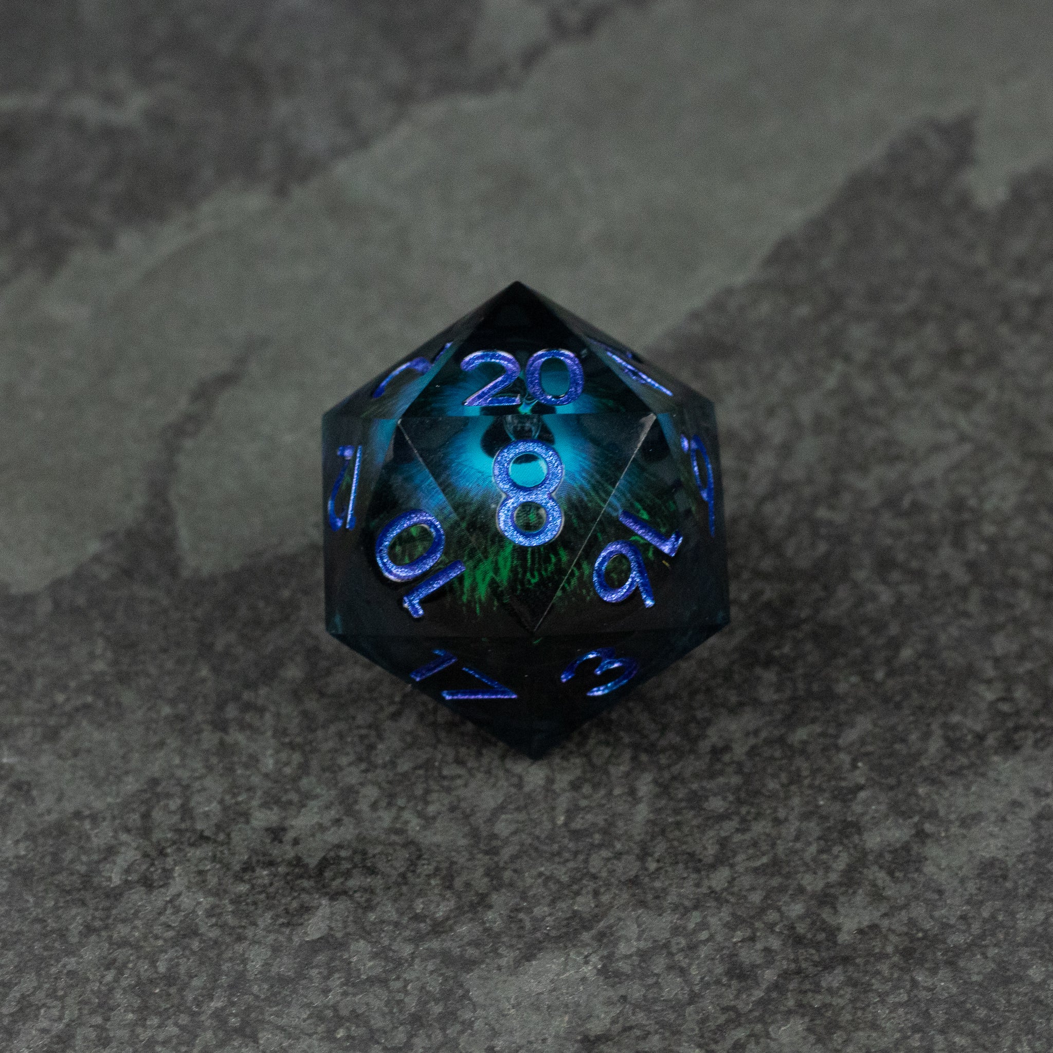 33mm Liquid Floating Eye - Blue - 33mm black d20 dice with glowing blue liquid core and neon blue numbers on gray surface.
