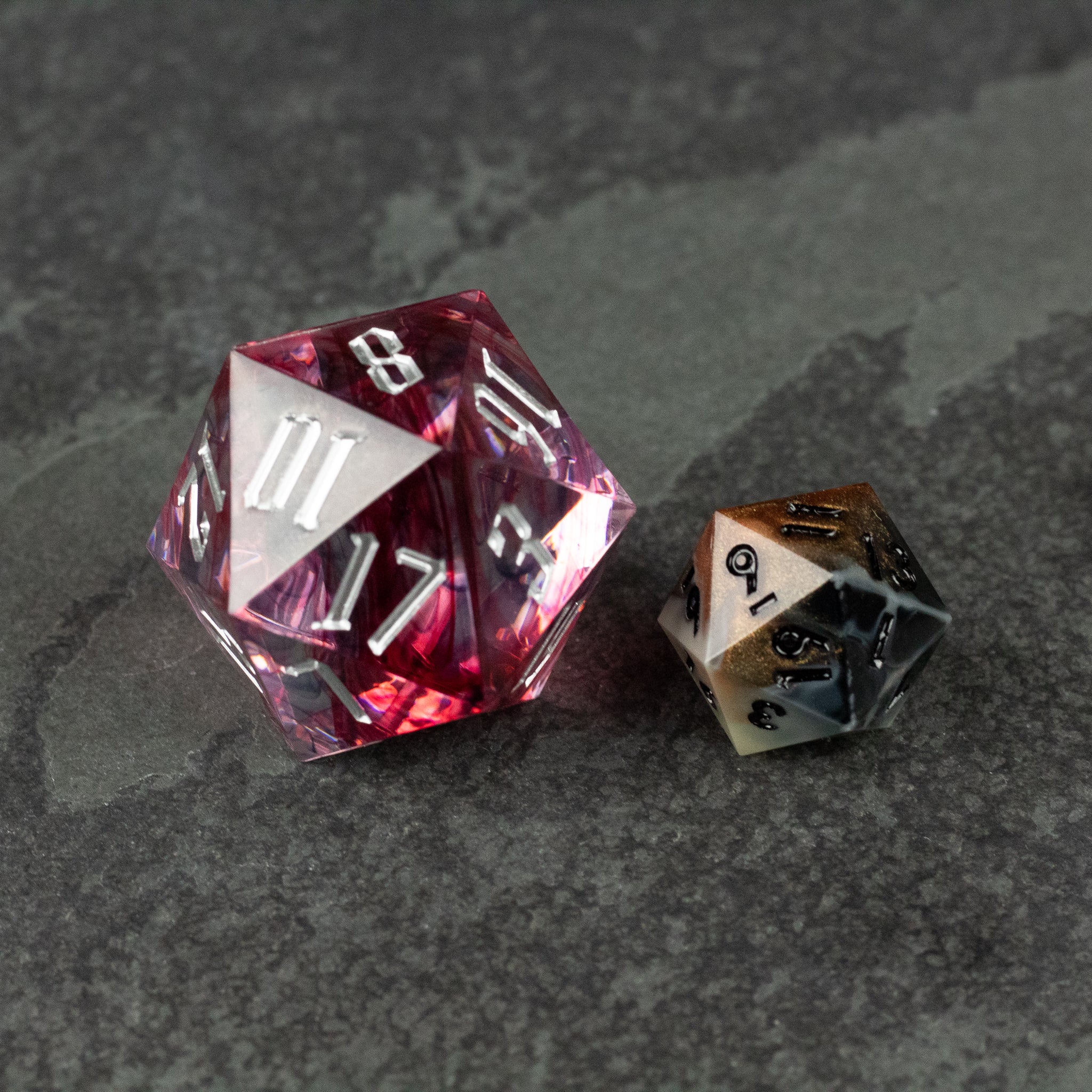 33mm Red Swirl D20 - Transparent red 33mm d20 dice with white numbers and swirl pattern next to smaller black and white d20 dice.