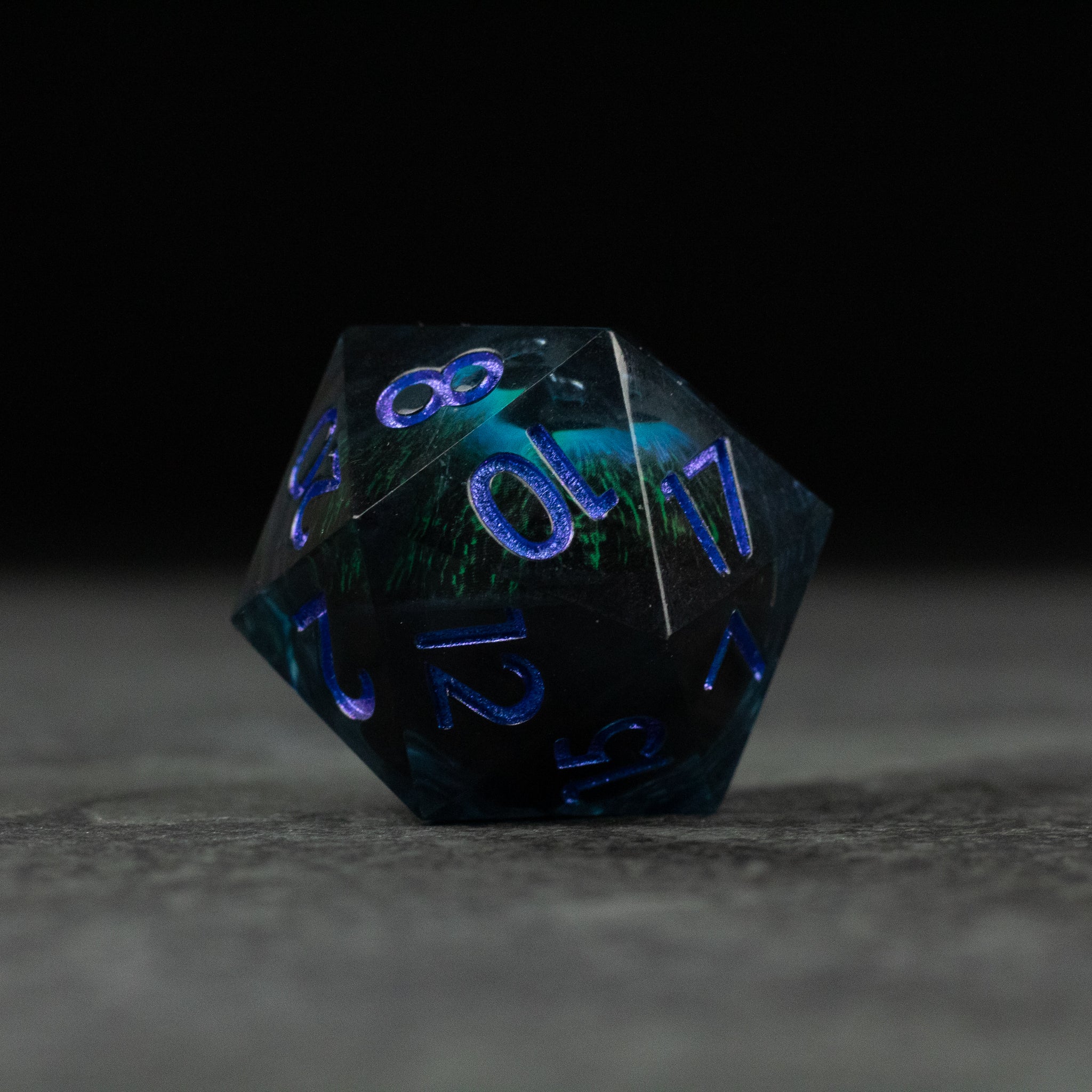 33mm Liquid Floating Eye - Blue - 33mm translucent dark blue 20-sided die with floating liquid core and glowing blue numbers.