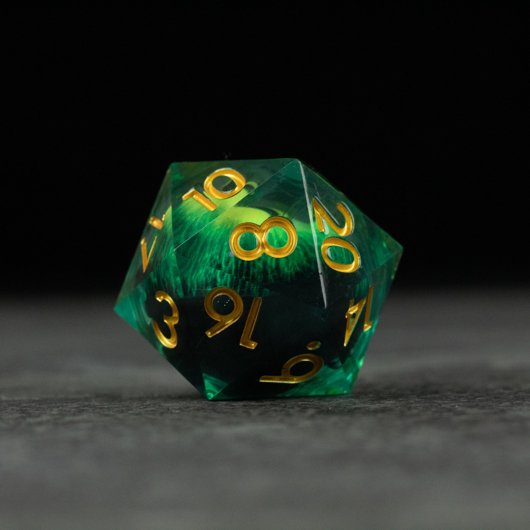 33mm Liquid Floating Eye - Green - 33mm translucent green 20-sided die with swirling liquid core and gold numbers.