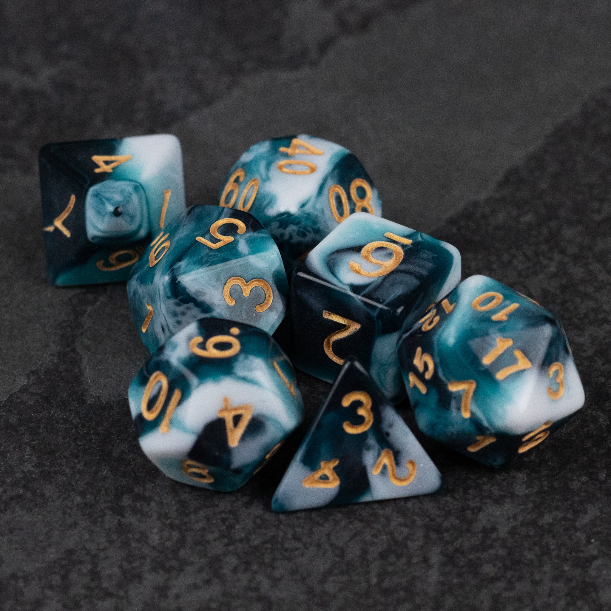 White and Teal Marbled Dice Set - White and teal marbled polyhedral dice set with gold numbers on a dark surface.
