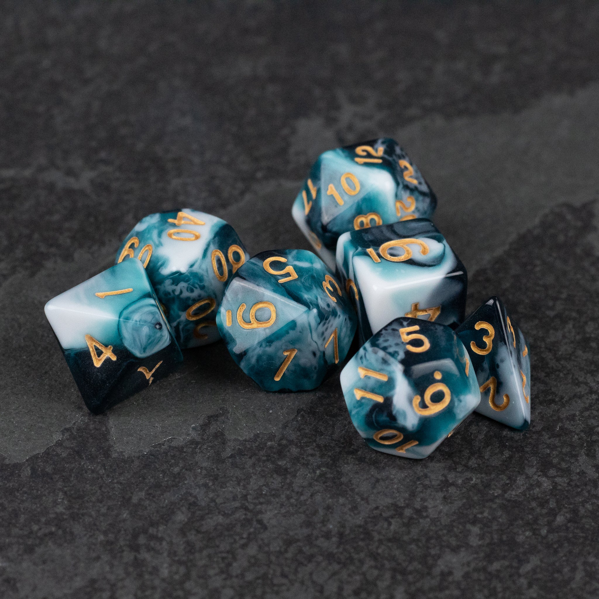 White and Teal Marbled Dice Set - White and teal marbled dice set with gold numbers on black textured surface.