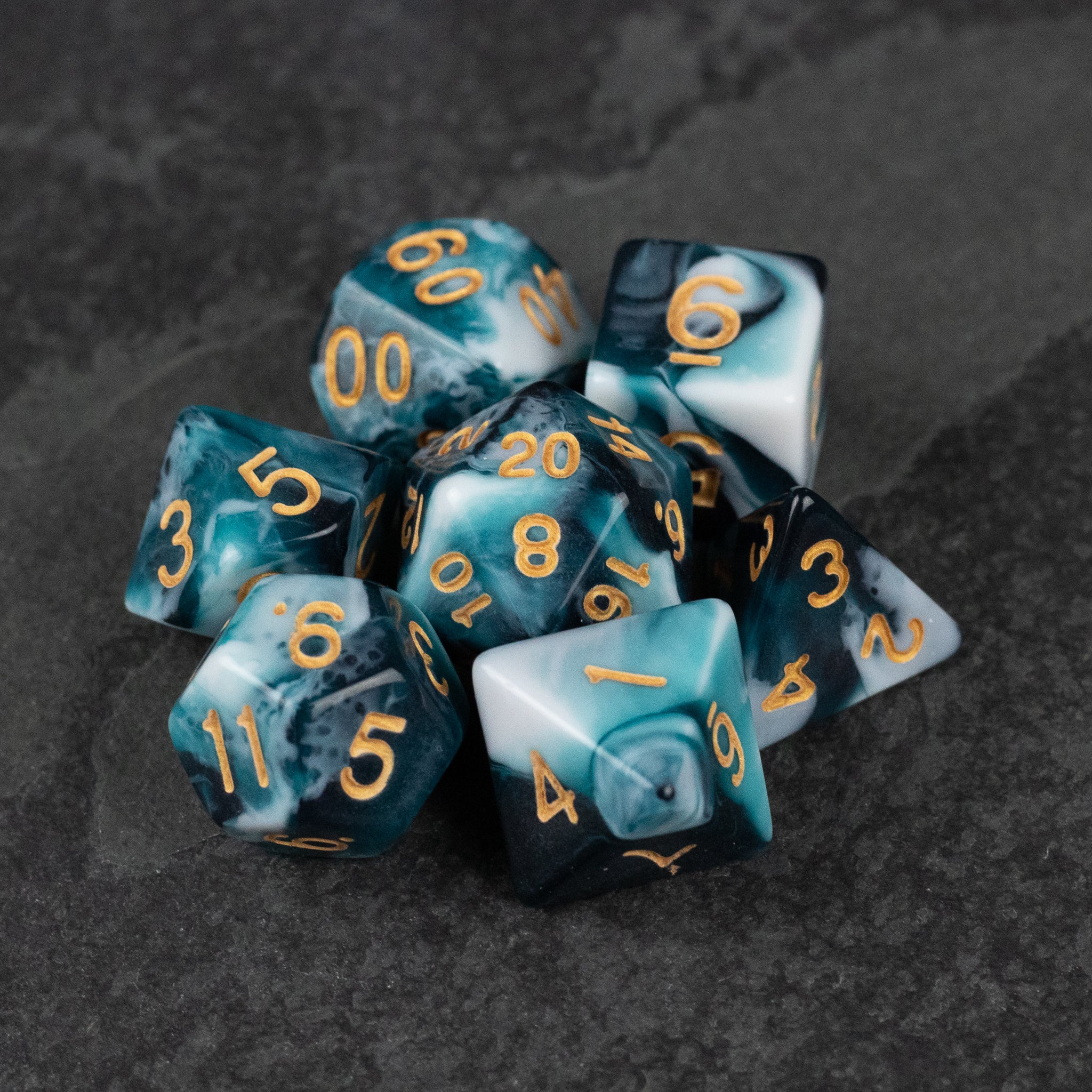 White and Teal Marbled Dice Set - White and teal marbled polyhedral dice set with gold numbering on dark surface.