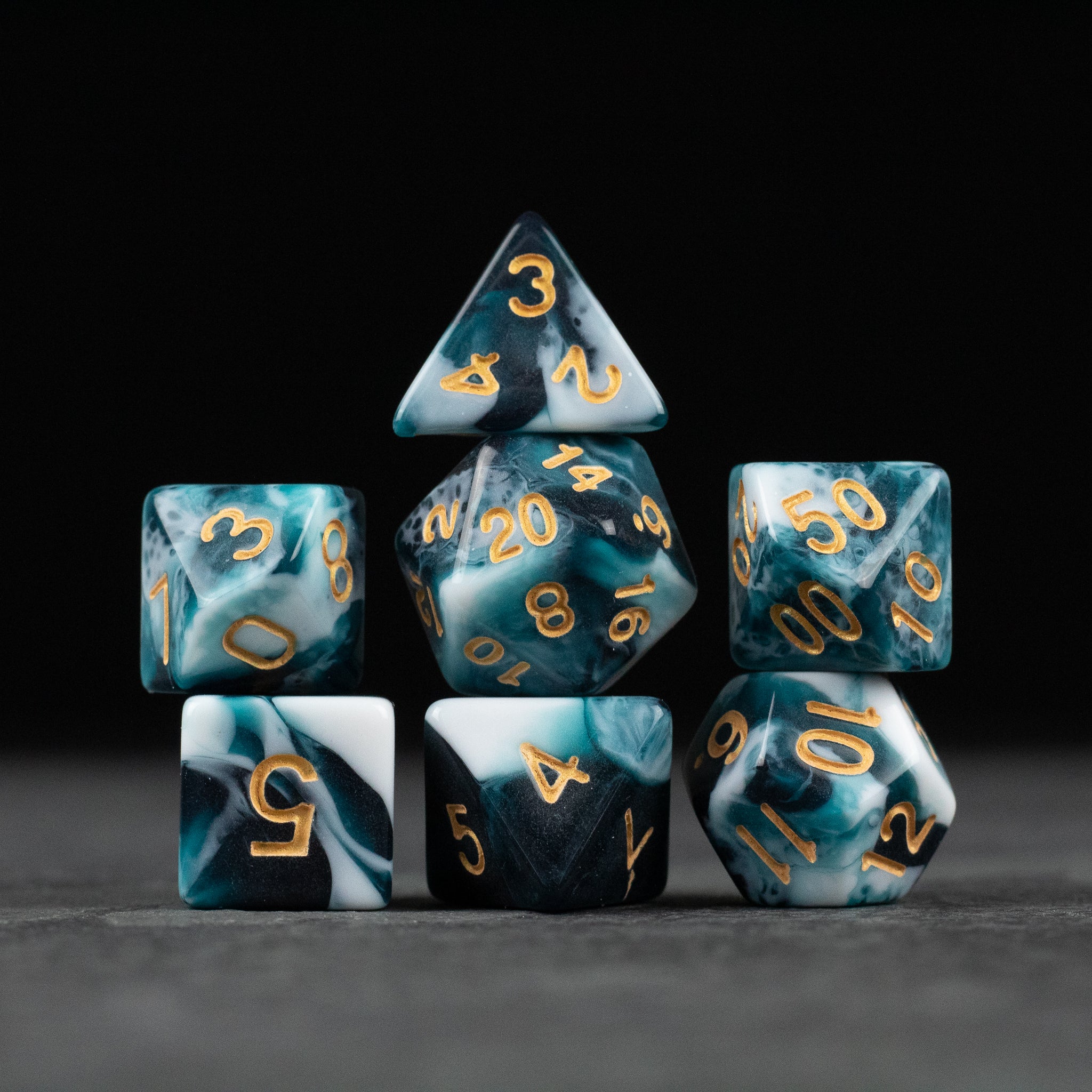 White and Teal Marbled Dice Set - Seven white and teal marbled polyhedral dice with gold numbers for tabletop gaming.
