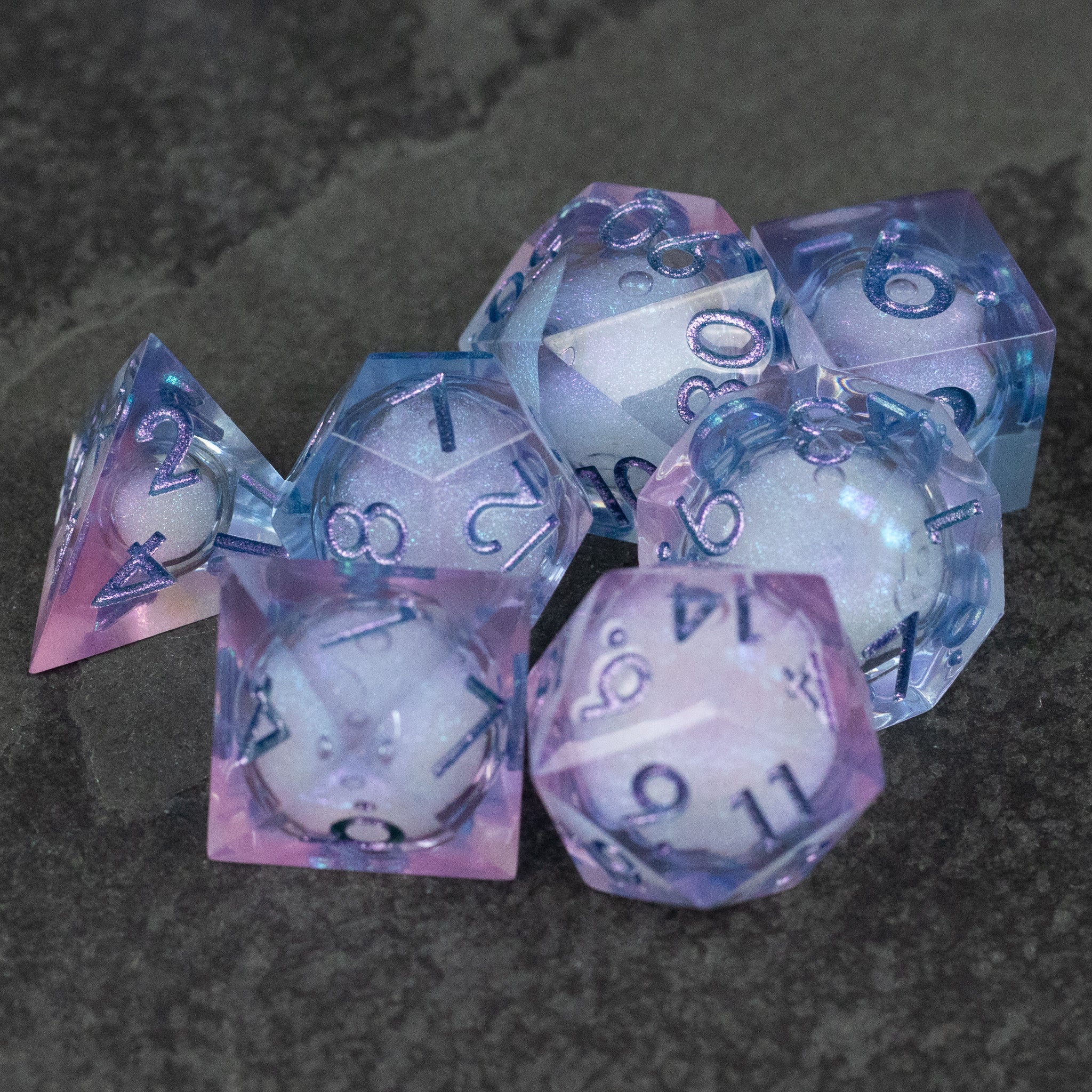 Fae Magic - Liquid Core Dice Set - Translucent purple and pink polyhedral dice set with swirling liquid core and light blue numbering.