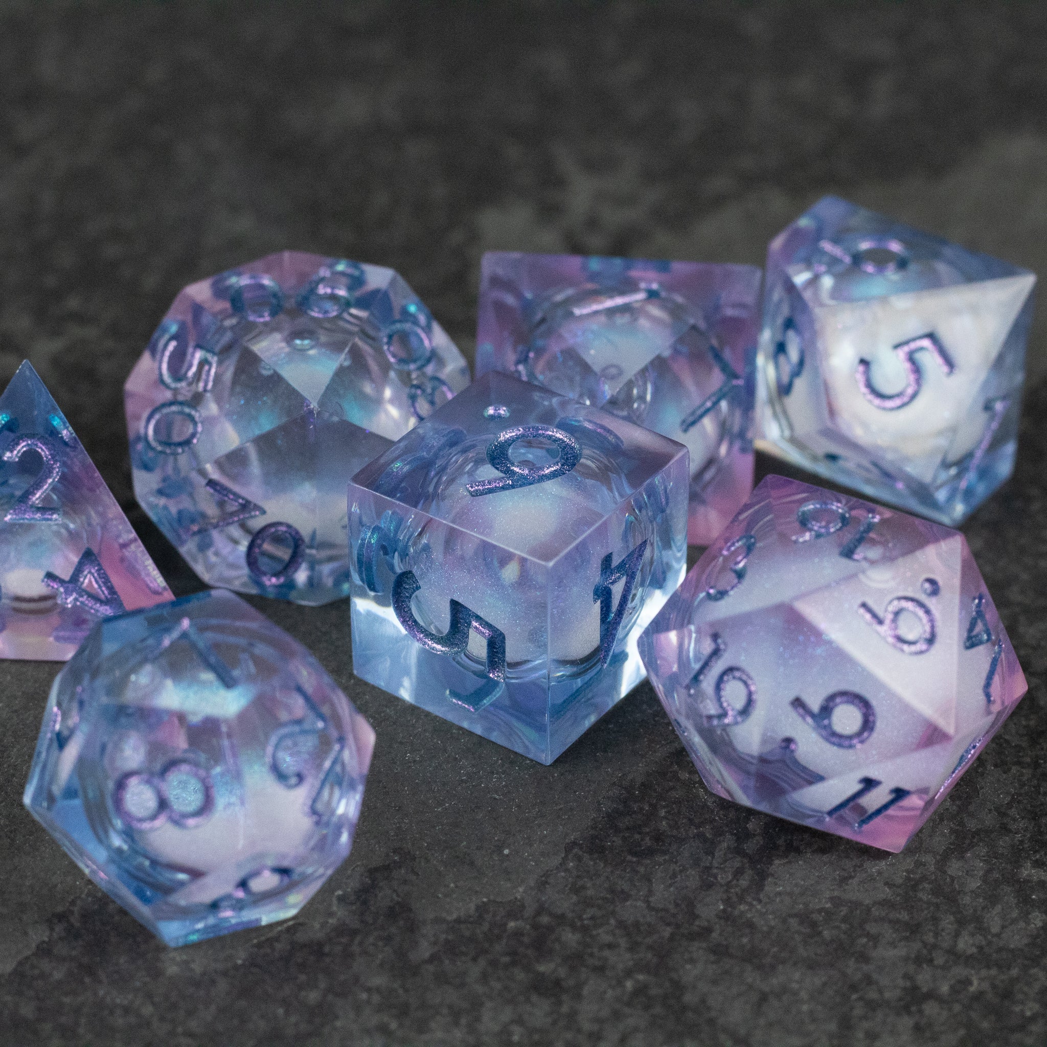 Fae Magic - Liquid Core Dice Set - Translucent purple seven-piece polyhedral dice set with swirling liquid core and white numbering.