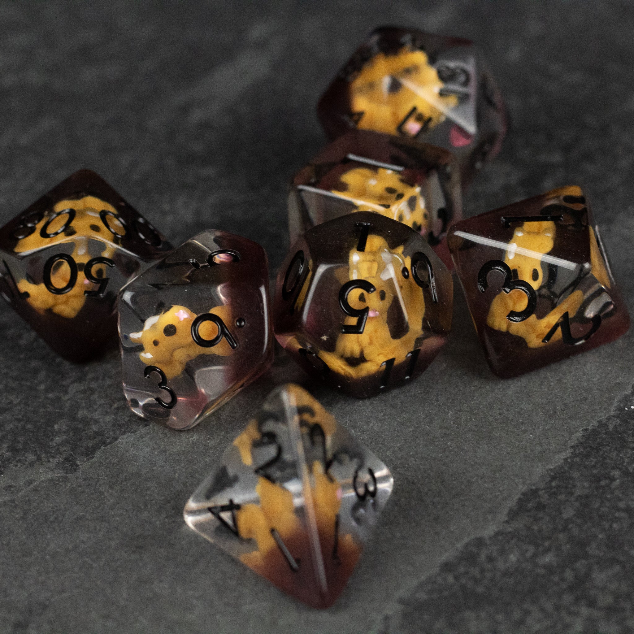 Squirrel Dice Set - Set of seven translucent polyhedral dice with black numbers and embedded tiny yellow squirrel figures inside.