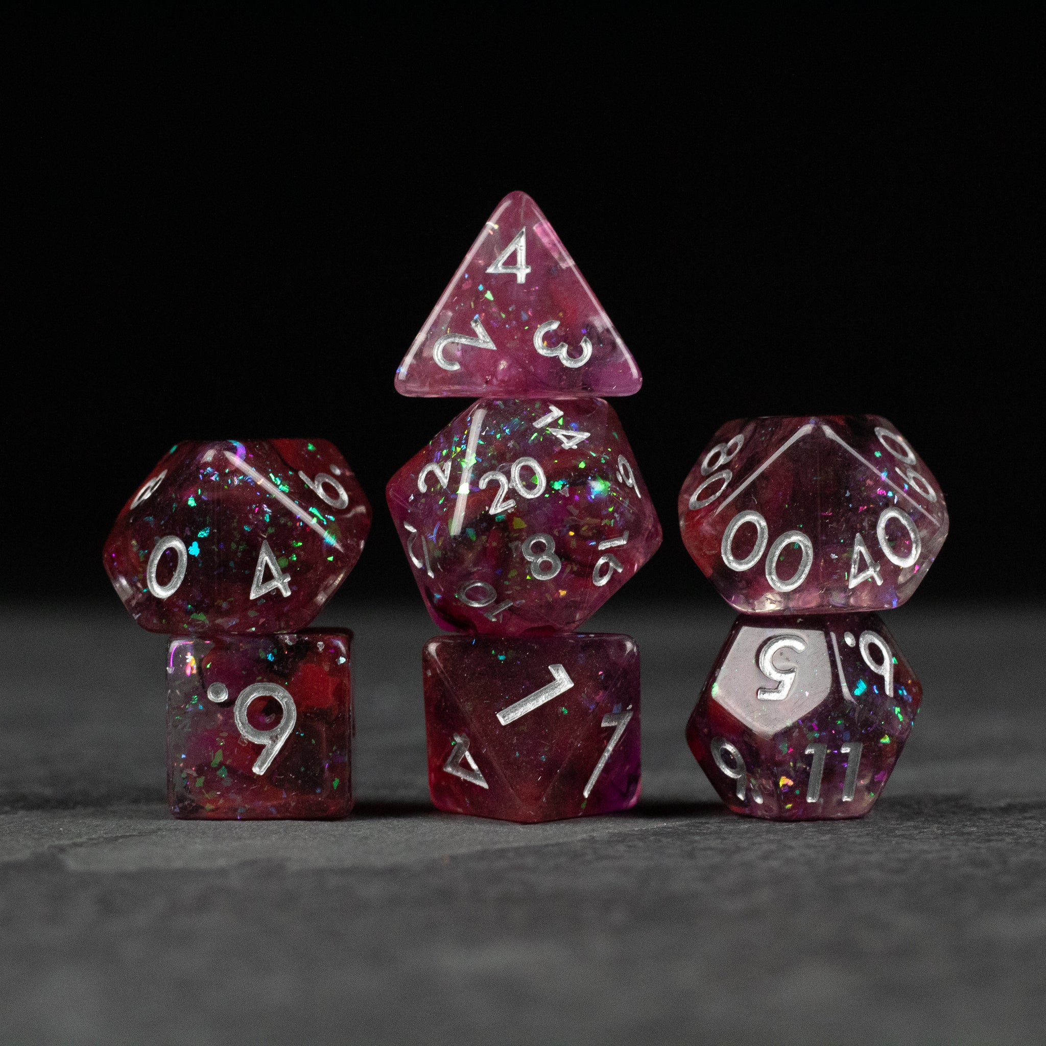 Black and red Spellweaver Dice Set - Seven black and red translucent polyhedral dice with white numbers for tabletop games.