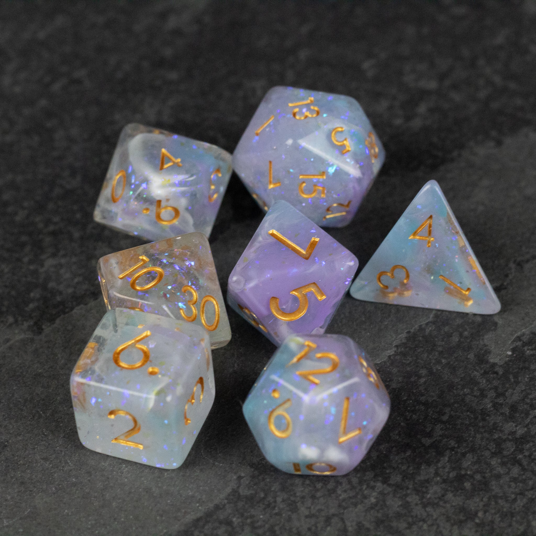 Spellbound Dice Set - Translucent purple and blue polyhedral dice with gold numbering, including d20, d12, d10, d8, d6, and d4, for tabletop.