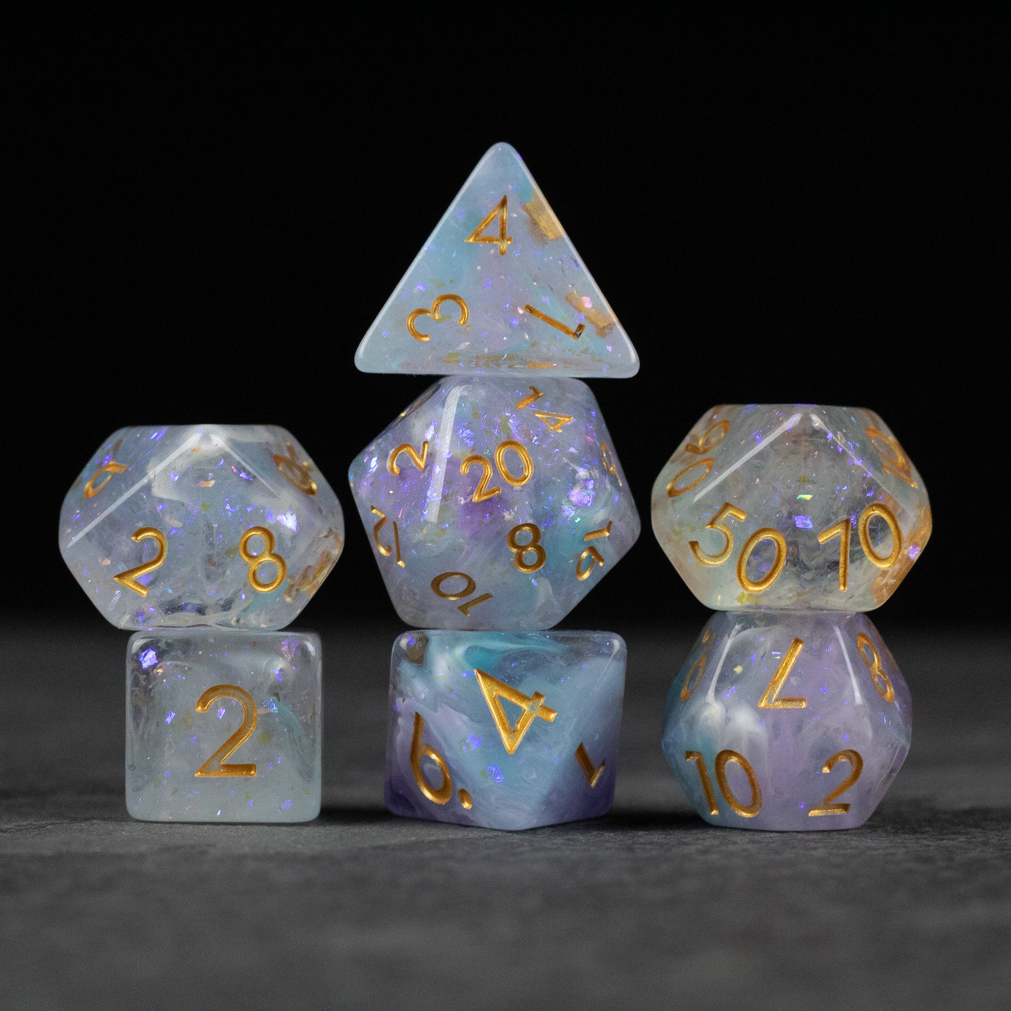 Spellbound Dice Set - Translucent purple and blue seven-piece polyhedral dice set with gold numbering.