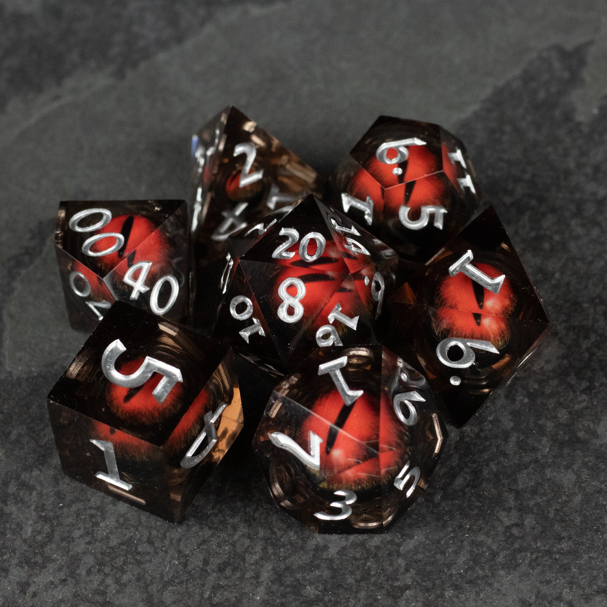 Orange Beholder's Eye Dice Set - Set of sharp-edged polyhedral dice with orange liquid core and white numbers on black edges.