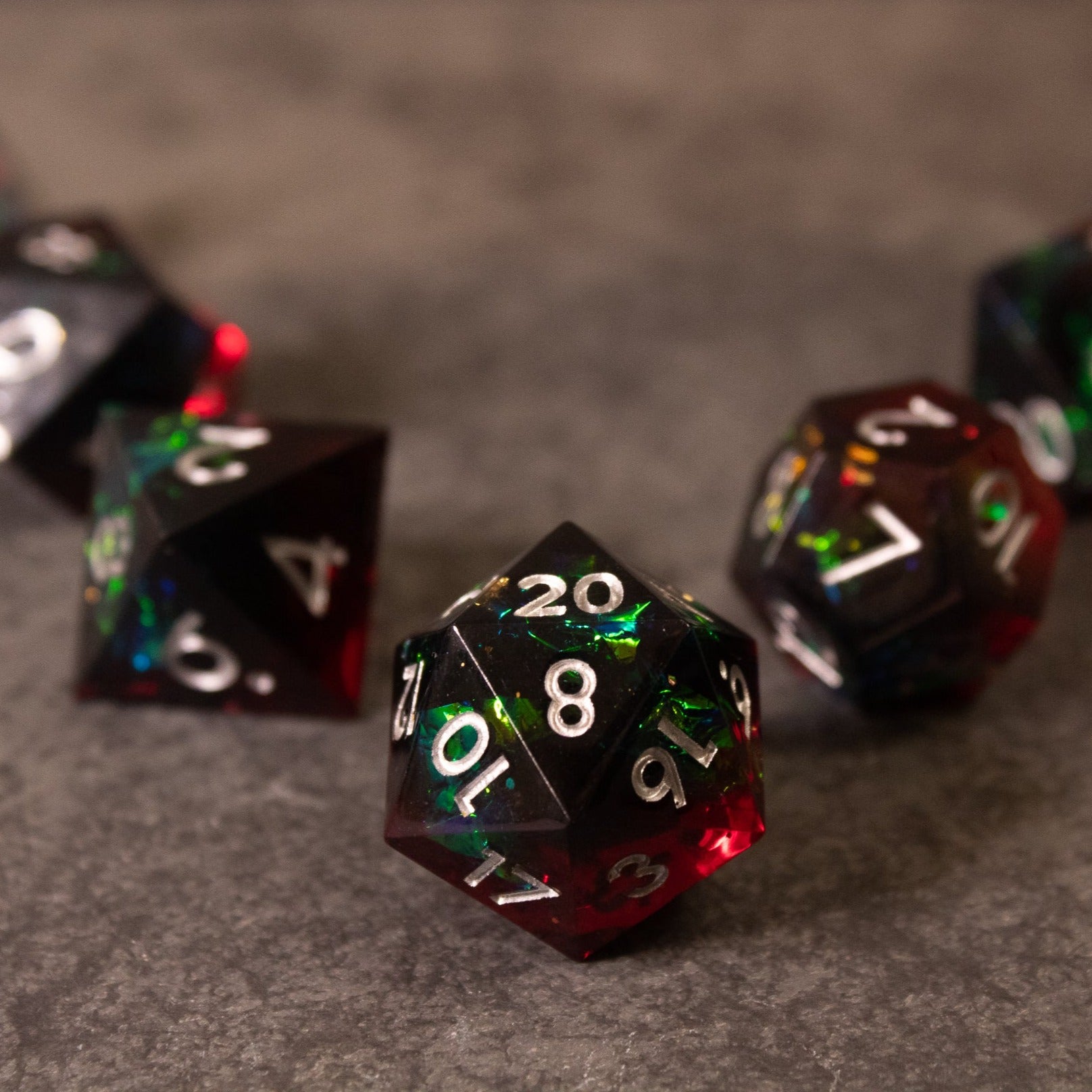Blood Magic - Sharp Edge Opalescent Dice - Set of sharp-edged twenty-sided dice with opalescent red, green, and black colors and white numbers.