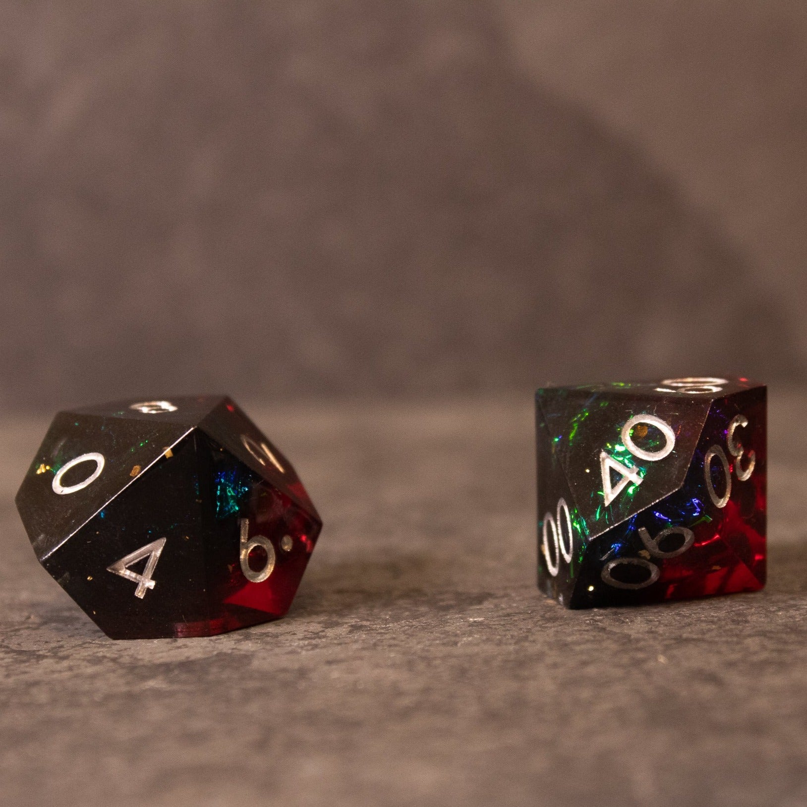Blood Magic - Sharp Edge Opalescent Dice - Two sharp-edged 20-sided dice with opalescent red and black coloring and white numbers.