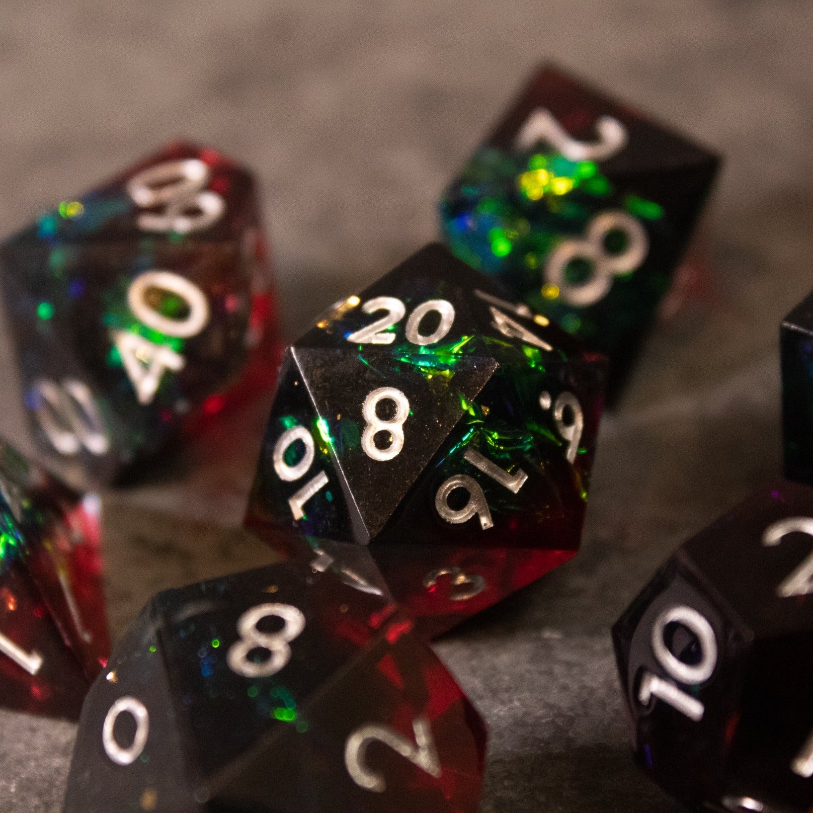 Blood Magic - Sharp Edge Opalescent Dice - Sharp-edged black and red opalescent polyhedral dice with glowing green and blue inclusions and white numbering.