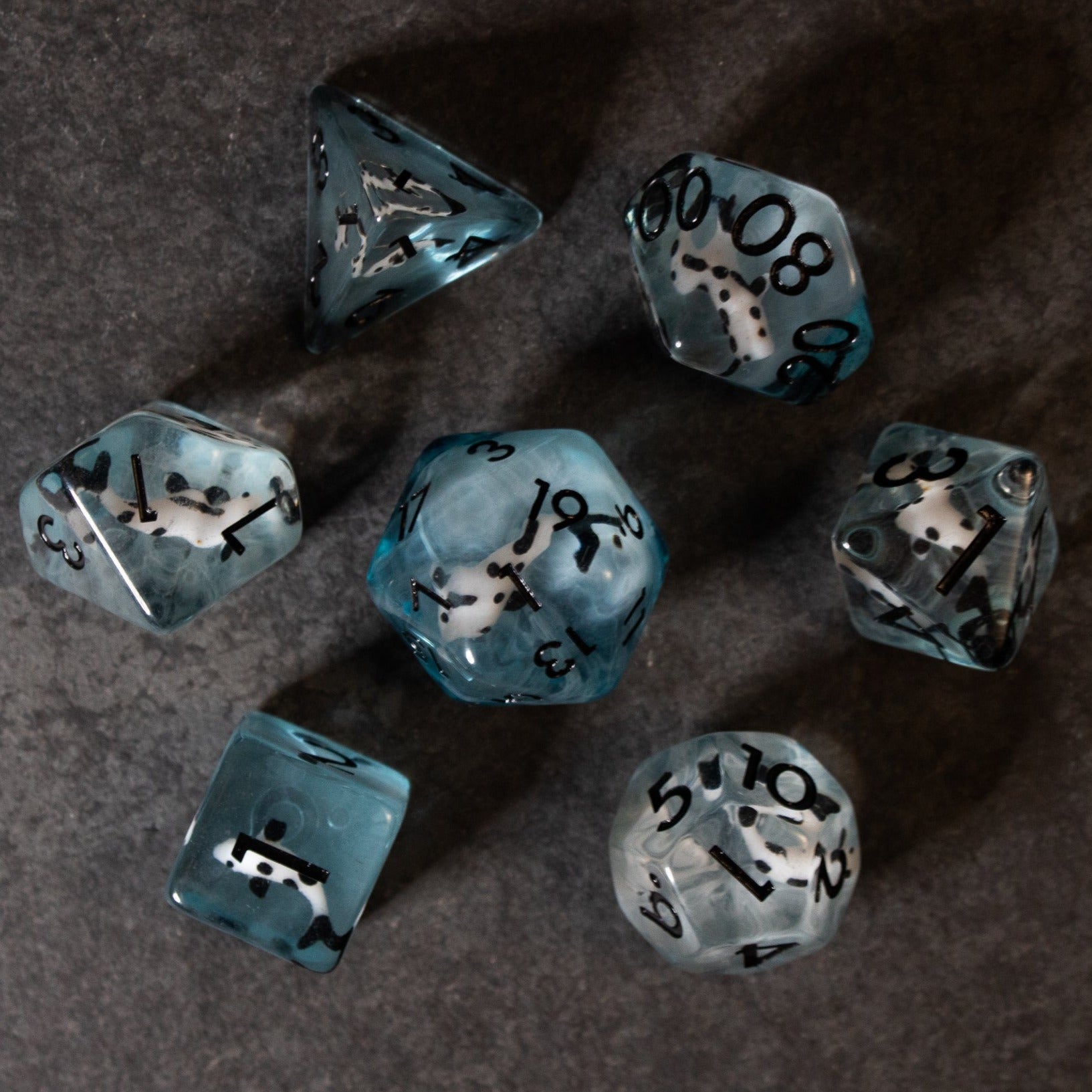 Black Koi & Steel Blue Dice - Set of seven steel blue and black koi fish-themed polyhedral dice with black numbering on a dark surface.